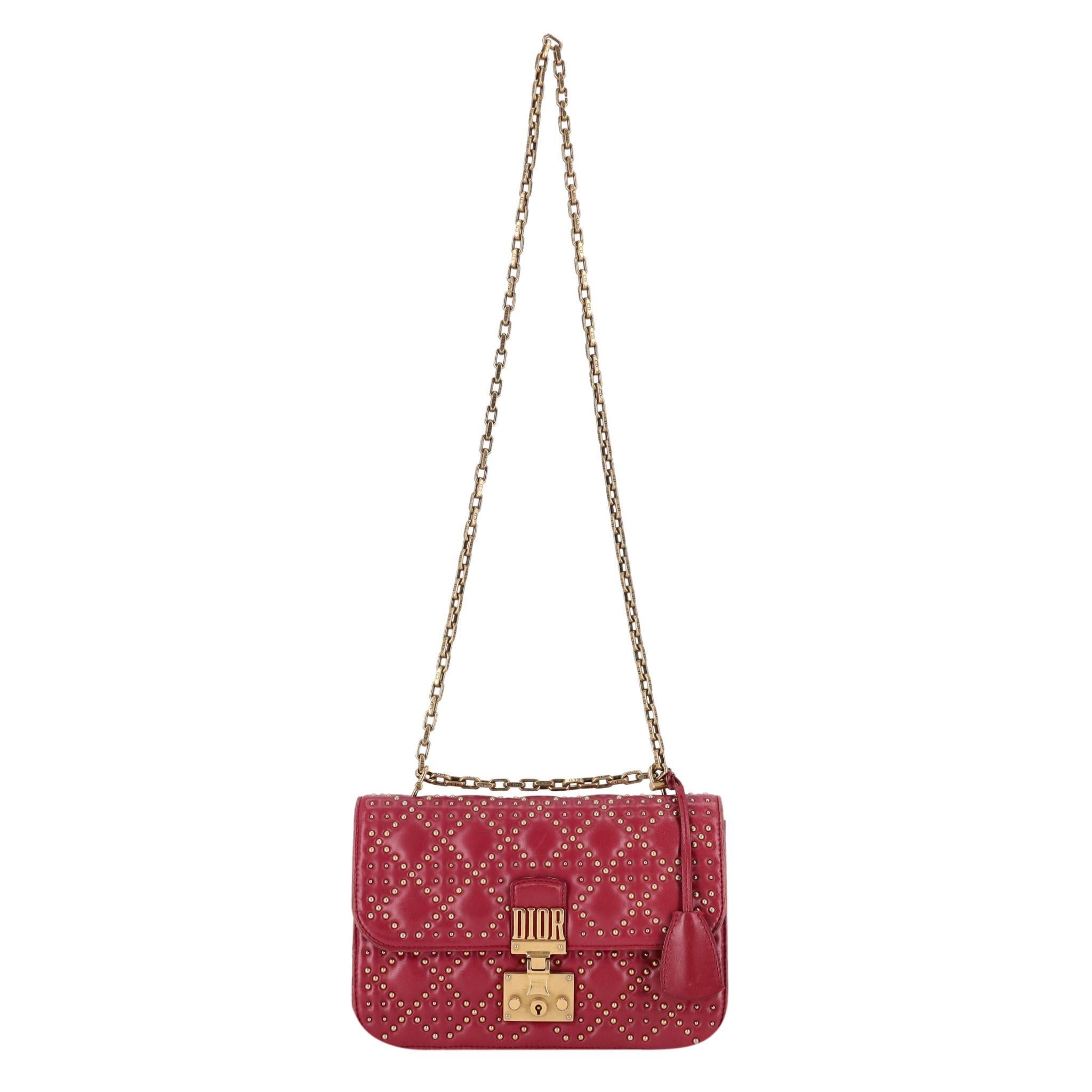 Christian Dior Cannage Dioraddict Large Studded Bag 

Red leather crossbody bag designed with gold studded, quilted body.

Aged gold hardware, front flap with 'DIOR' push-lock closure and detachable 'CD' engraved chain-link shoulder strap.

Tonal