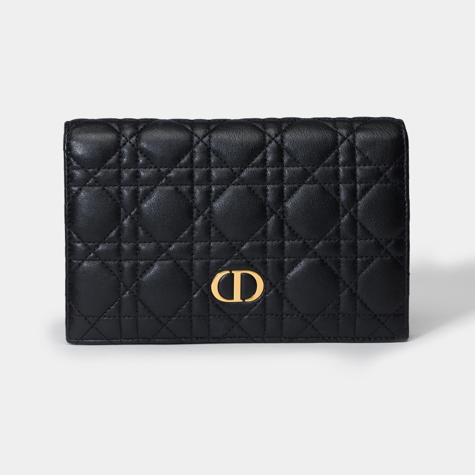 Le portefeuille long Dior Caro offre une version contemporaine de l'emblématique couture Cannage. Confectionné en cuir de veau noir, il est doté d'un rabat rehaussé d'une signature CD sur le devant. Compagnon chic et spacieux, ce portefeuille peut