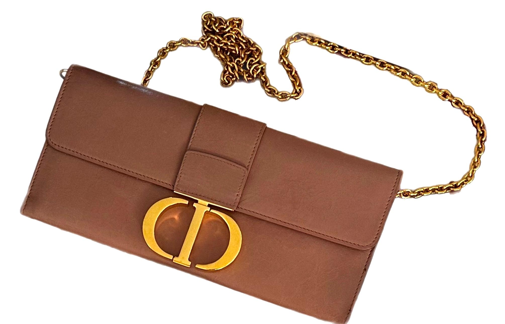 The Christian Dior CD Logo Chain Wallet Bag in Beige is a sophisticated and versatile accessory that exudes timeless elegance. Crafted from premium leather, it features the iconic CD logo in polished gold-tone hardware on the front, adding a refined