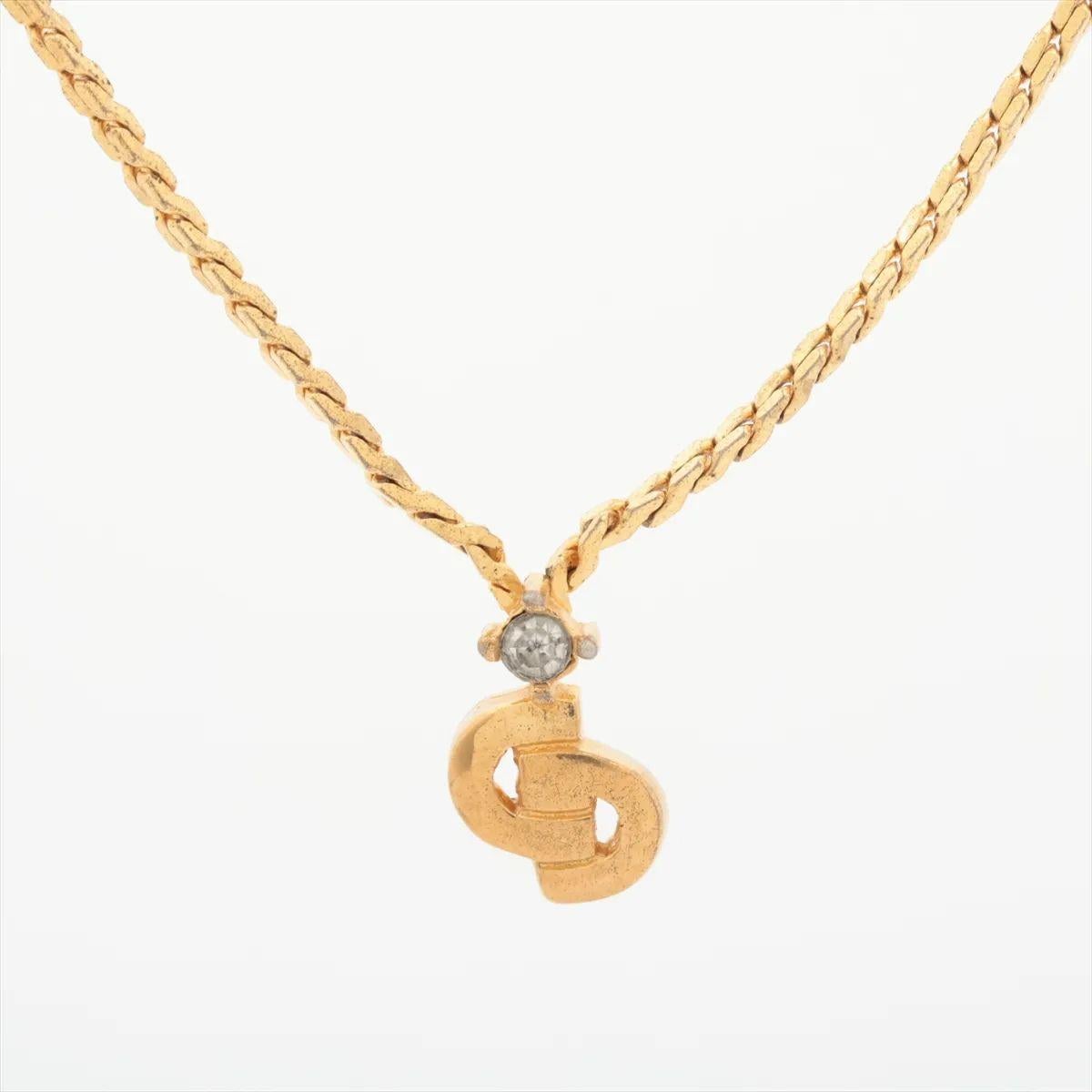Die Christian Dior CD Logo Strass-Anhänger-Halskette in Goldton ist ein schickes und strahlendes Stück, das die Essenz von dezentem Luxus einfängt. Der Anhänger mit den kultigen 