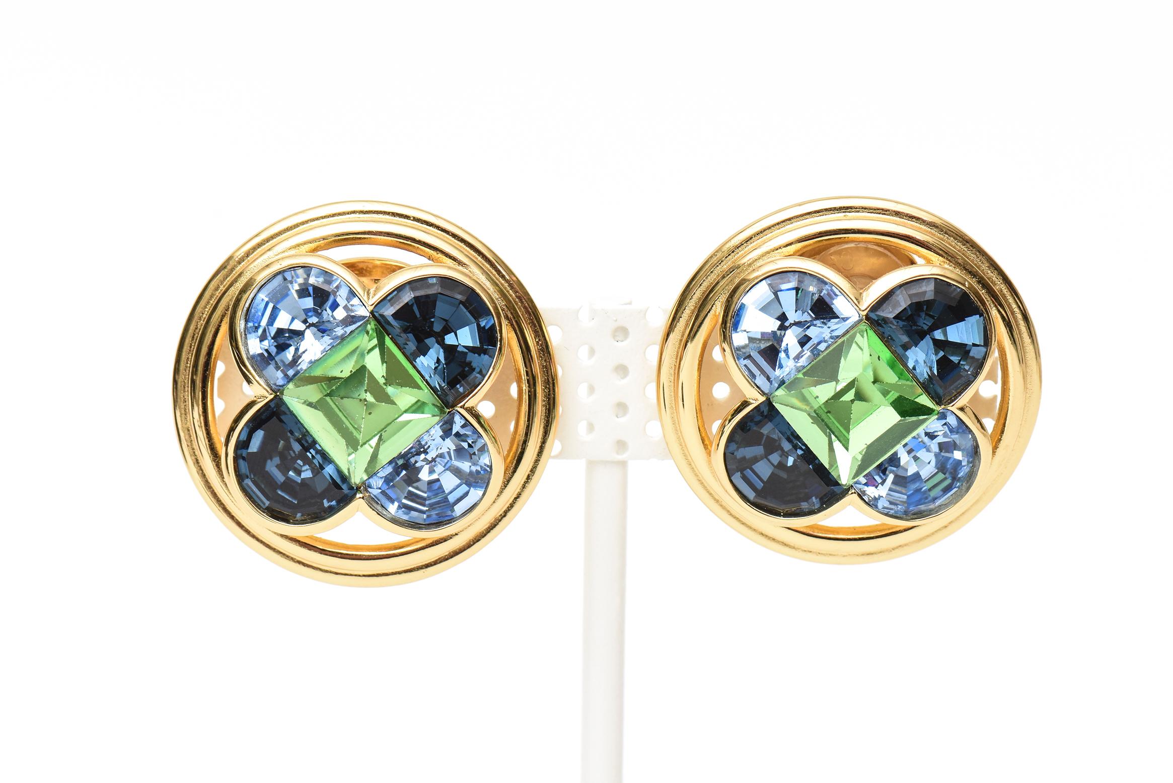 These very 80's round button clip on Christian Dior pair of earrings are a beautiful combination colors of green and blue crystals set against a gold tone background. They are perfect for all the seasons of 2023. They are marked Christian Dior. They