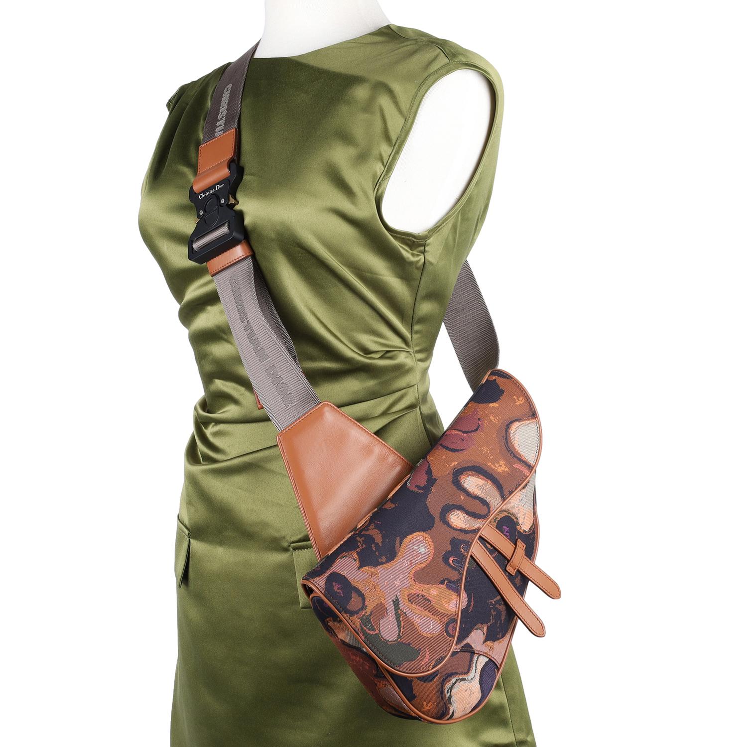 Authentic Christian Dior Coated Canvas Diamond Printed Mens Saddle Bag in Brown. Features Dior monogram canvas in brown and beige, brown calfskin leather accents, a CD logo buckle and an adjustable shoulder strap with the Christian Dior logo, front