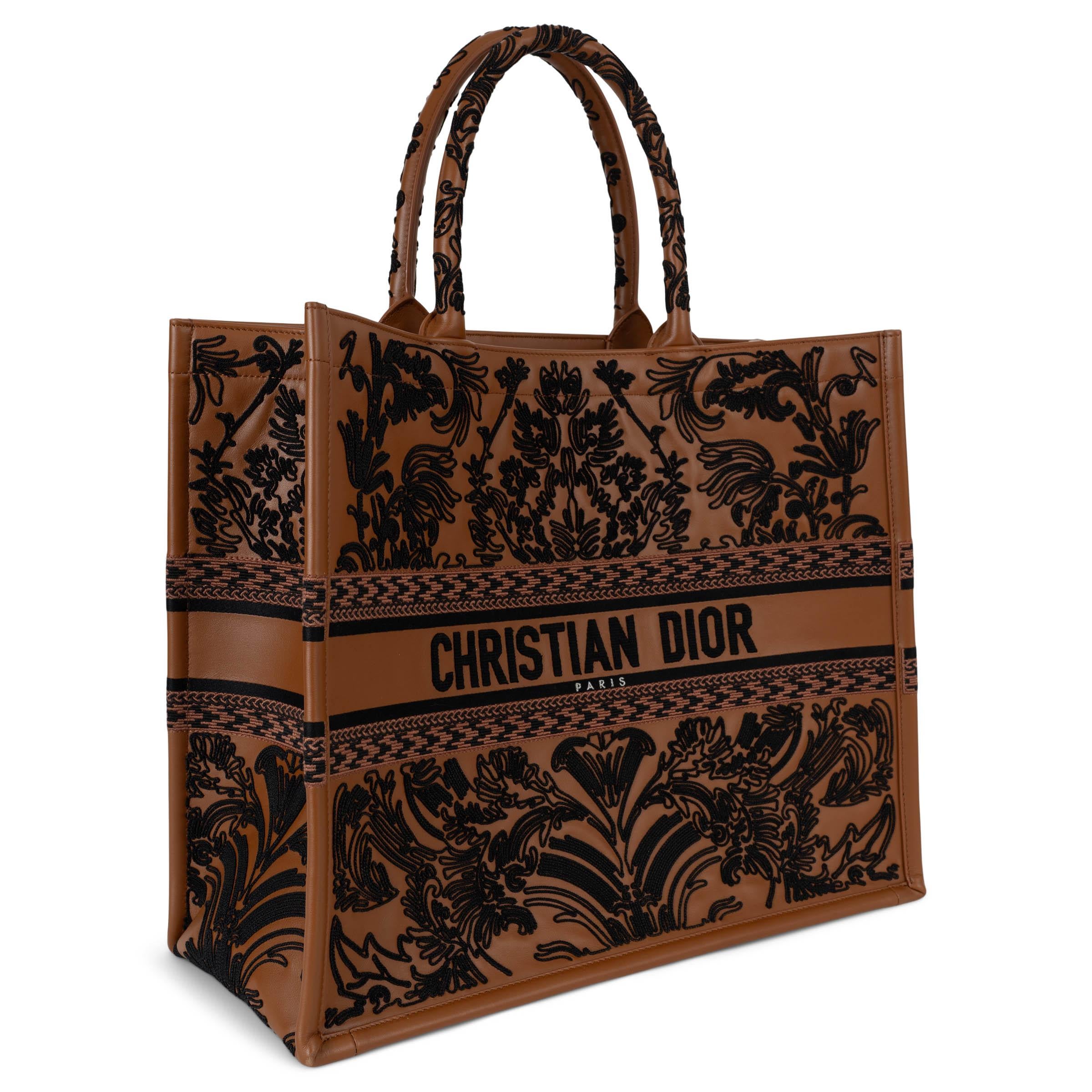 This 100% authentic Christian Dior Large Book Tote in brown lambskin leather is a stunning tribute to craftsmanship and heritage. Embroidered with a black cornely-effect ornamental motif inspired by the Andalusian Baroque period, it showcases Dior's