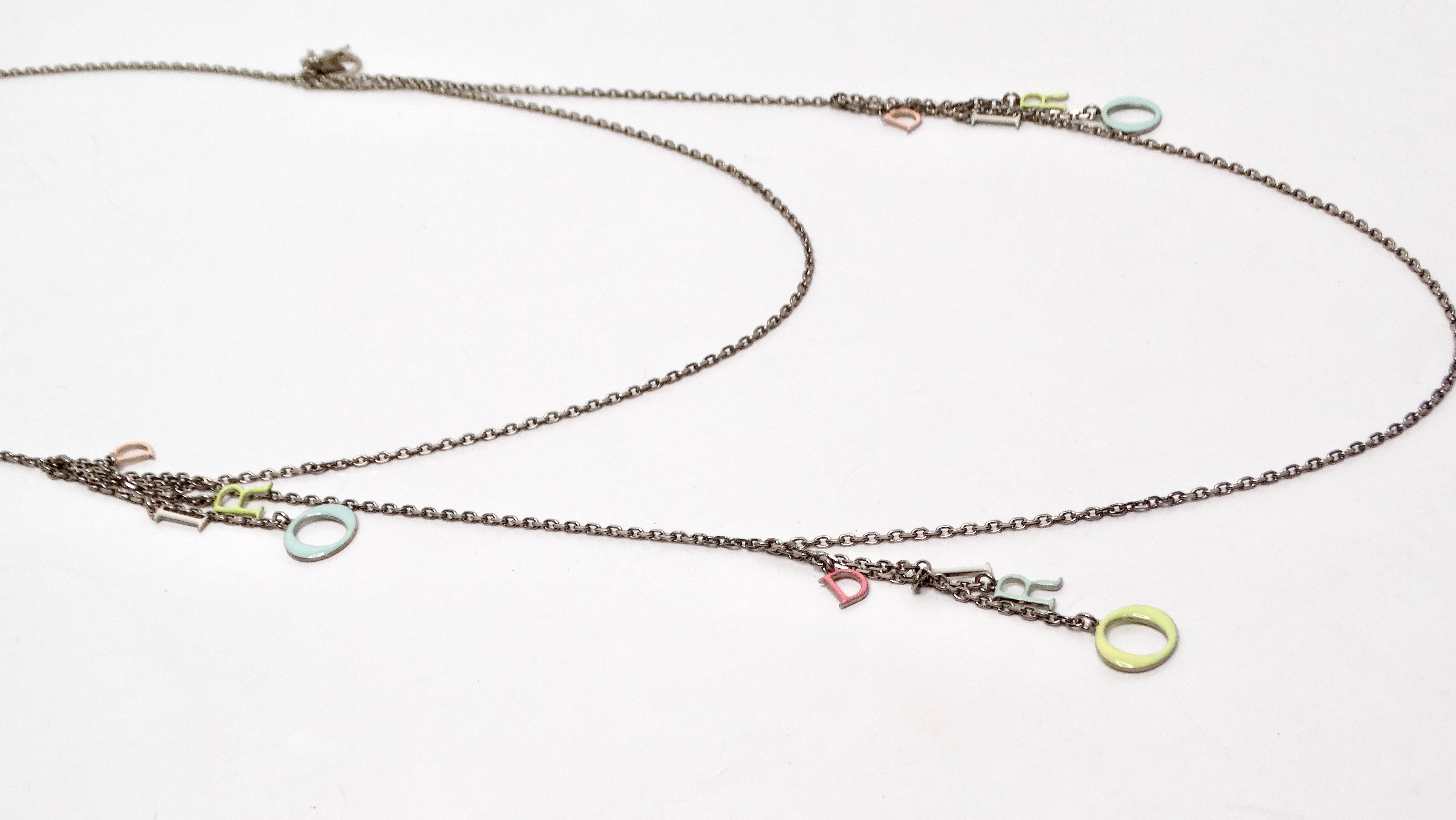 Le collier à chaîne double brin Christian Dior Colorful Logo Charm est une pièce étonnante qui rehausse sans effort n'importe quel ensemble grâce à son design à la fois ludique et sophistiqué. Ce collier unique se compose d'une chaîne en argent qui