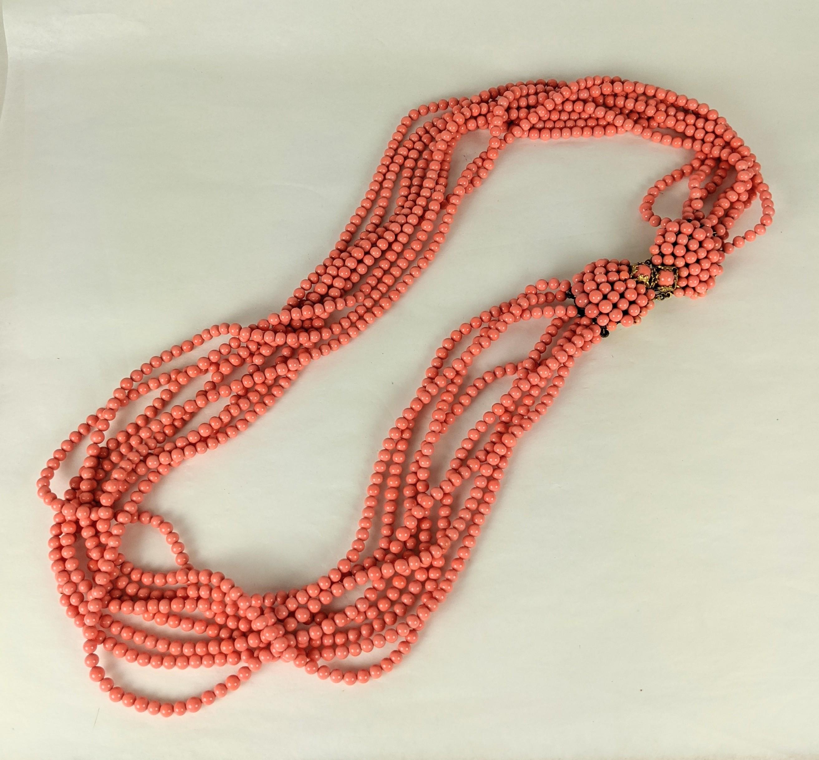 Christian Dior faux coral pate de verre long torsade necklace. Consisting of eight strands of the pale orange coral glass beads with double clasp of hand sewn scallop shaped shell motifs in gilt bronze.
Excellent Condition, Marked France. Unsigned