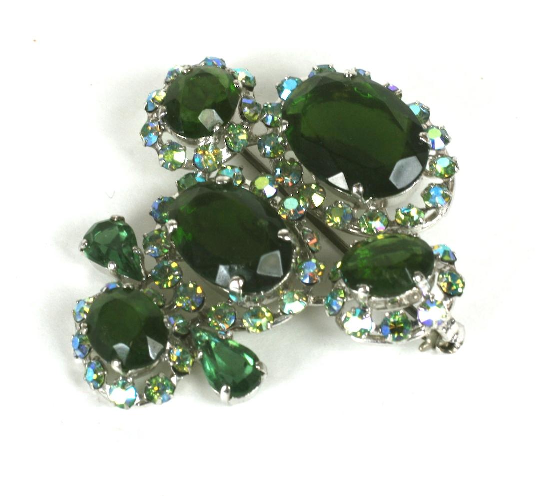Christian Dior Haute Couture Regency style brooch of olivine crystal faceted oval and teardrop stones accented with pale blue aurora borealis round crystals. 1950's France.
Excellent Condition, Signed, early oval plaque.
Length 2
