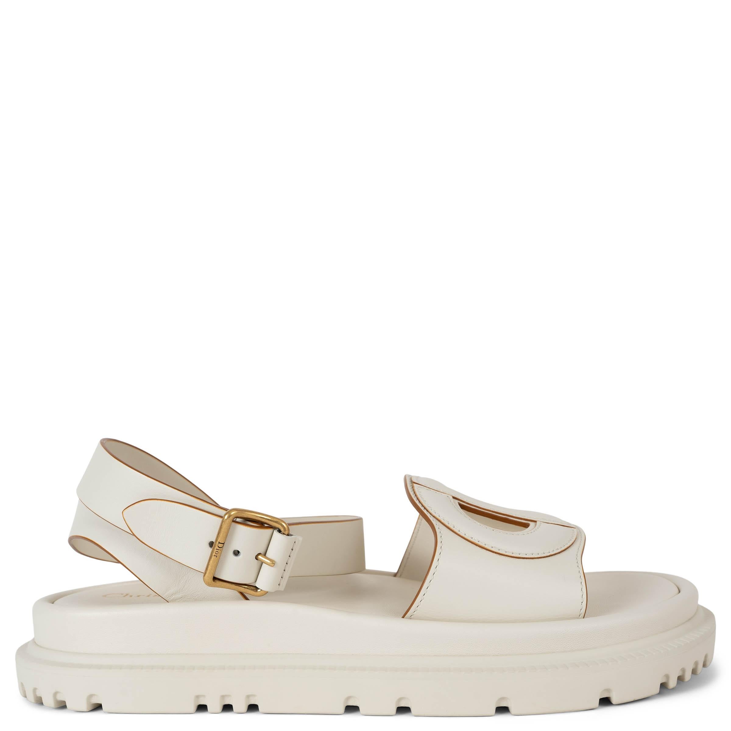 These 100% authentic Christian Dior D-Club sandals in cream calfskin leather combine timeless elegance with modern comfort. Featuring an openwork CD front strap and ankle straps with gold-tone buckles, they are finished with contrasting edge paint
