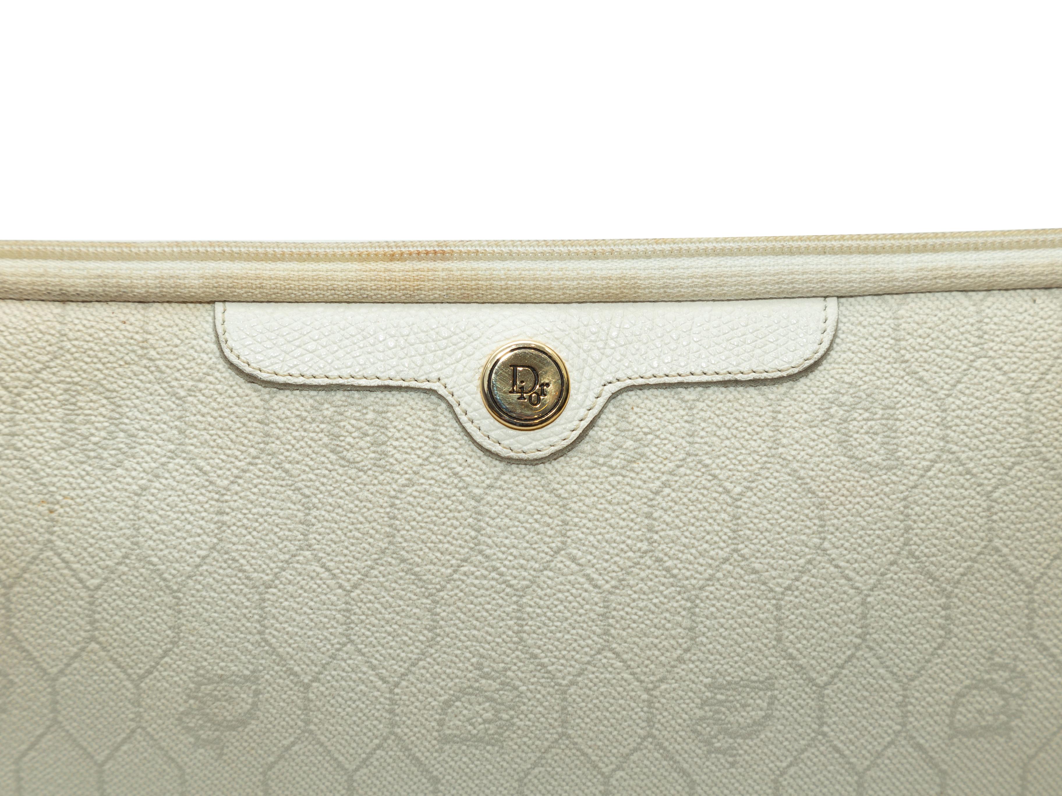 Product details: Vintage cream leather clutch by Christian Dior. Tonal logo print throughout. Zip closure at top. 11