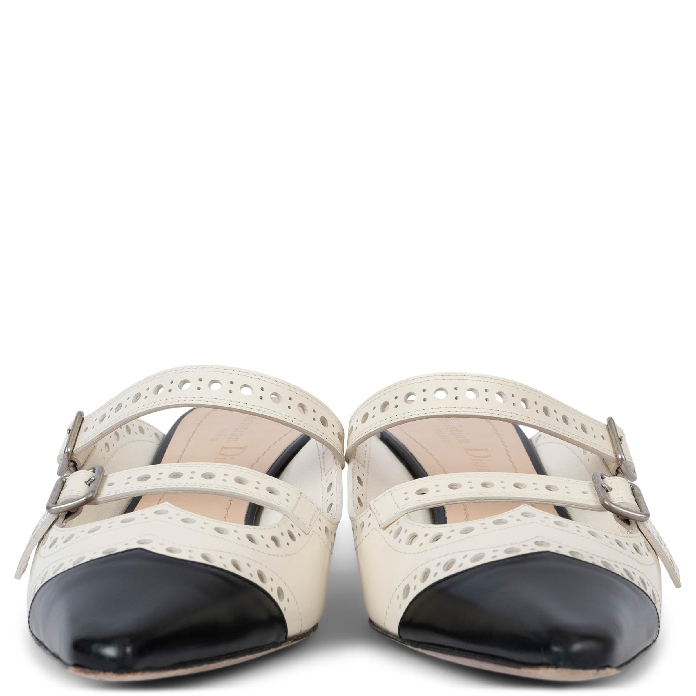 100% autentici Christian Dior Spectadior, muli con tacco a gattino in pelle di vitello spazzolata traforata ecrù e nera con finiture in argento. Sono stati indossati e sono in ottime condizioni. Sono dotati di sacchetti per la polvere.
