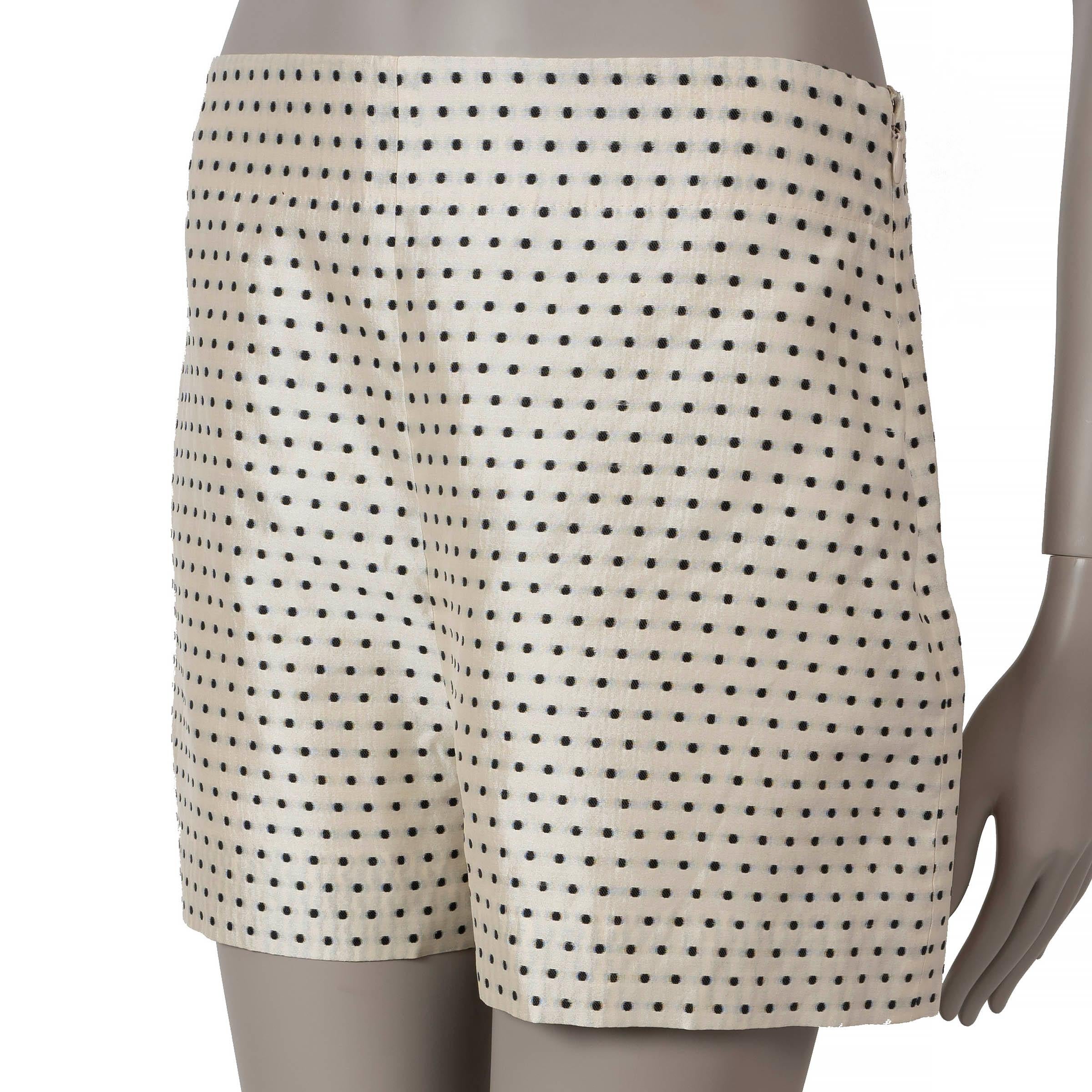 These 100% authentic Christian Dior mini shorts are crafted from a luxurious blend of cream silk (81%) and cotton (19%) with playful black polka dots. They open with a zipper on the side for a sleek finish and are fully lined in silk (100%) for