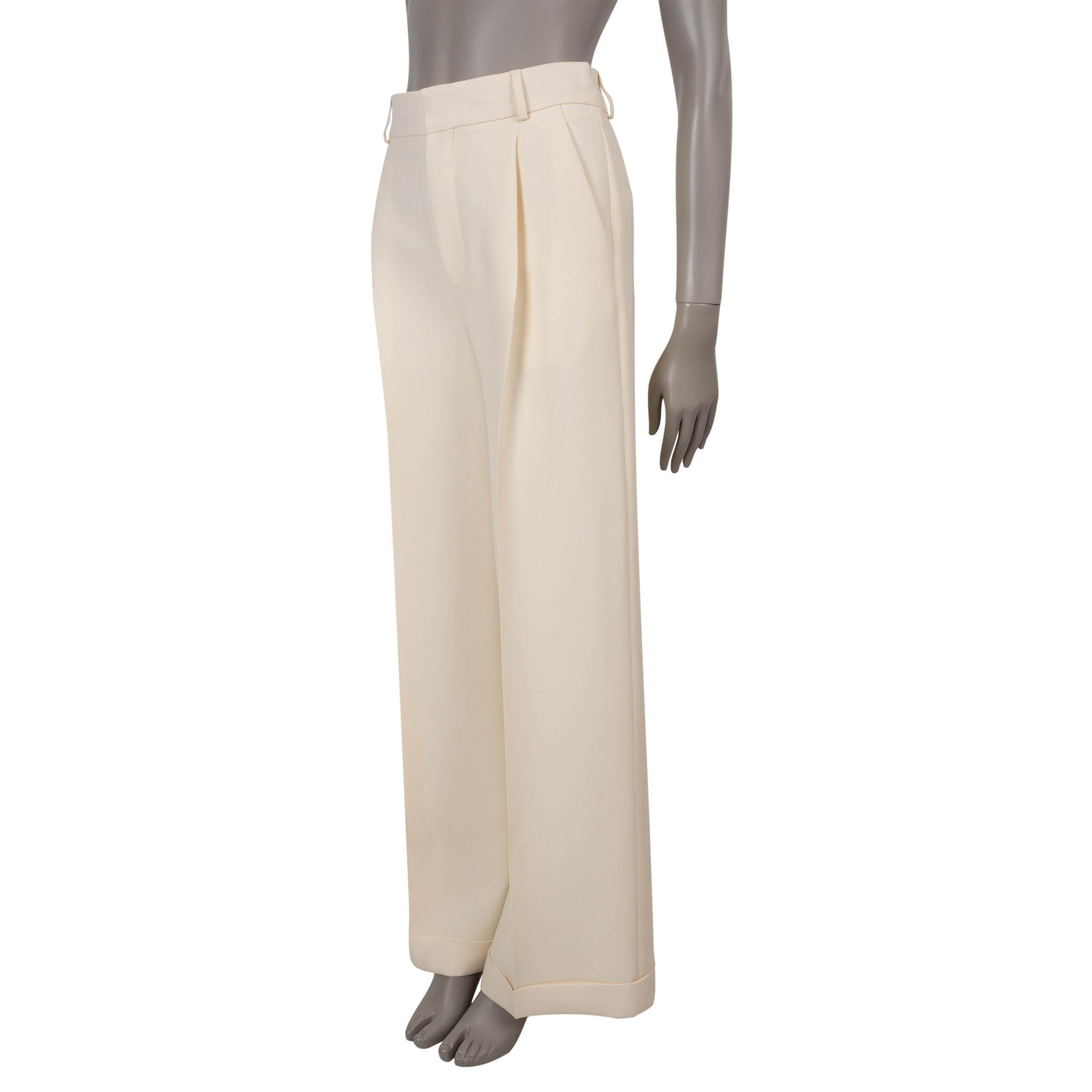 Ce pantalon Christian Dior 100% authentique en laine crème (77%) et soie (23%) est l'expression raffinée d'un tailleur classique avec une touche de féminité. Conçue avec une silhouette à taille haute et des jambes larges et évasées, elle présente
