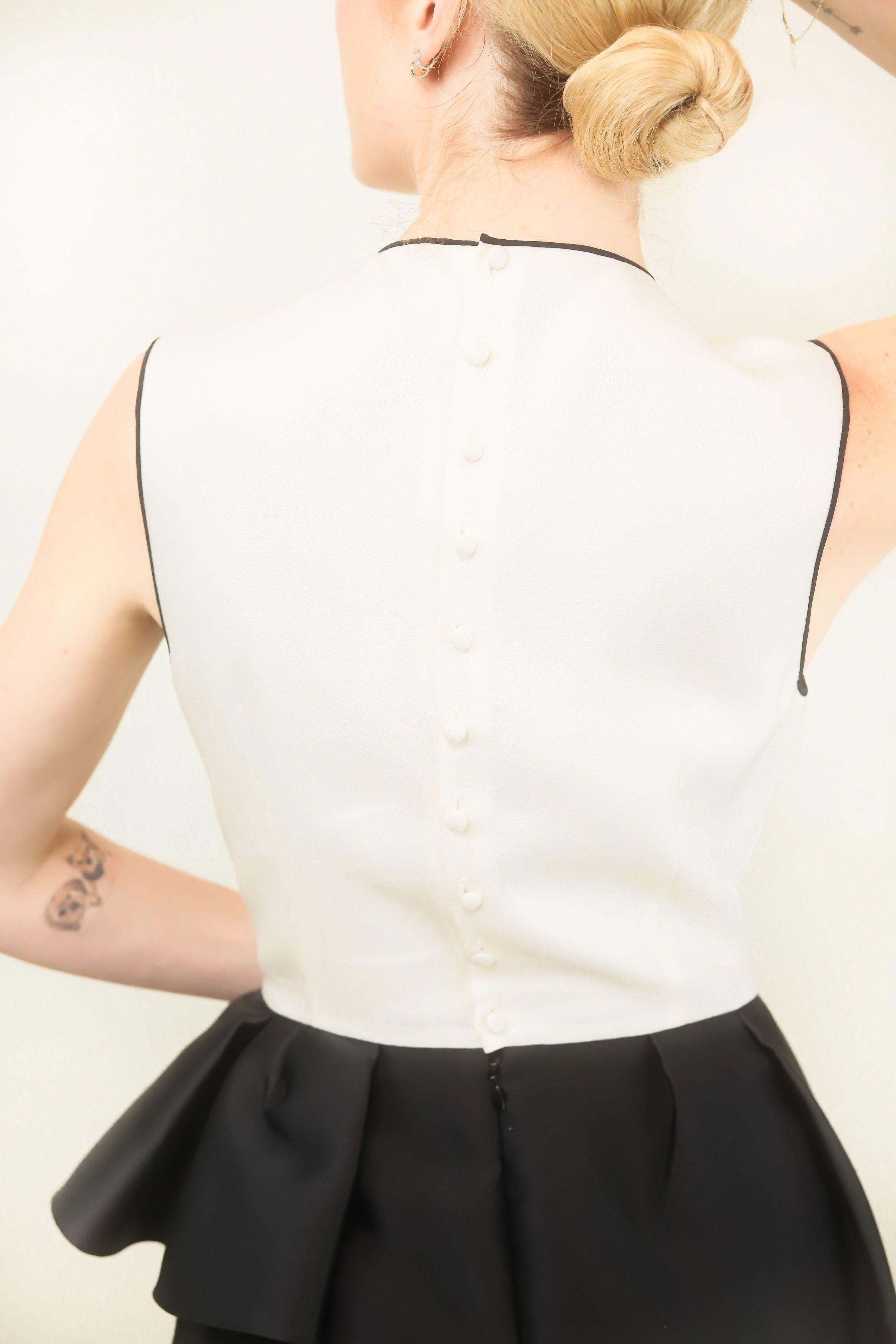 This silhouette is symbolic of classic Christian Dior style. A cinched waist, accentuated hips and color blocking contrast. This dress is exceptionally special and will serve as a collectors item for years to come. Perfect for an untraditional