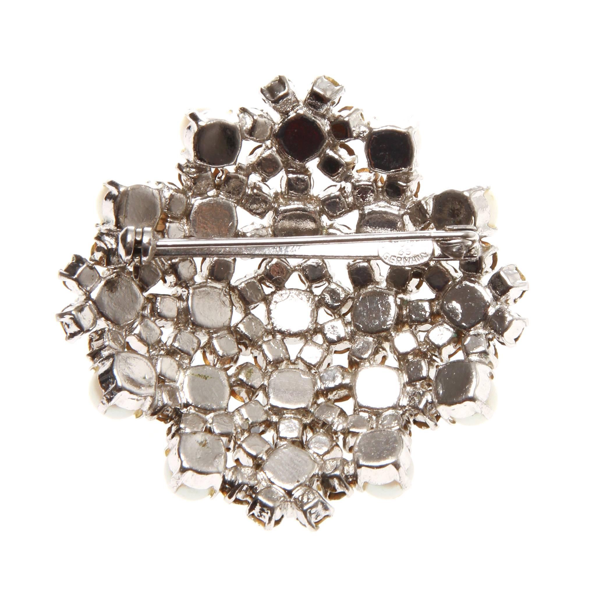 Christian Dior brooch featuring a cluster of clear Swarovski crystals and pearls in a silver setting. 

Branded stamp at back. Engraved Chr.Dior 65 Germany

Fastening: Roll needle