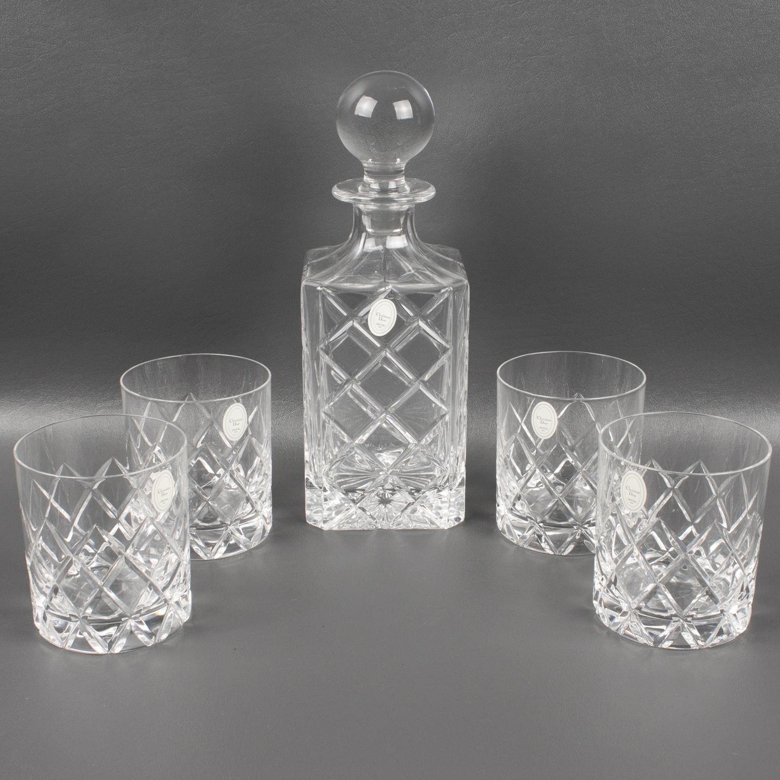 This superb crystal barware cocktail decanter with four tumbler glasses was designed, in Italy, for Christian Dior Home Collection. The stopper, container, and glasses are all cut and etched to upscale standard with a geometric pattern. The crystal