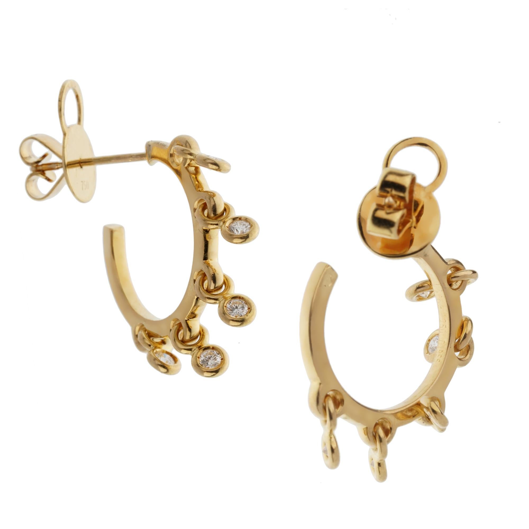 Une paire de boucles d'oreilles chic en diamant Christian Dior, avec 10 diamants ronds de taille brillante flottant librement sur un anneau en or jaune 18k. Les diamants ont un poids total de .30ct et mesurent 3/4