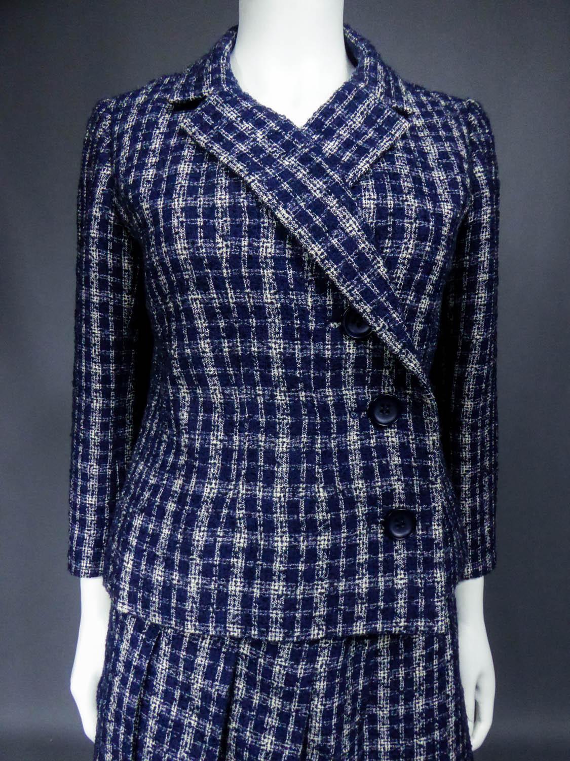 Circa 1962/1965
France

Skirt suit set, Demi Couture Christian Dior / Marc Bohan designer house for Berenice in Marseille from the years 1962/1965. Skirt suit in checked white and navy blue bouclé wool. Slightly fitted and flared jacket on the hips