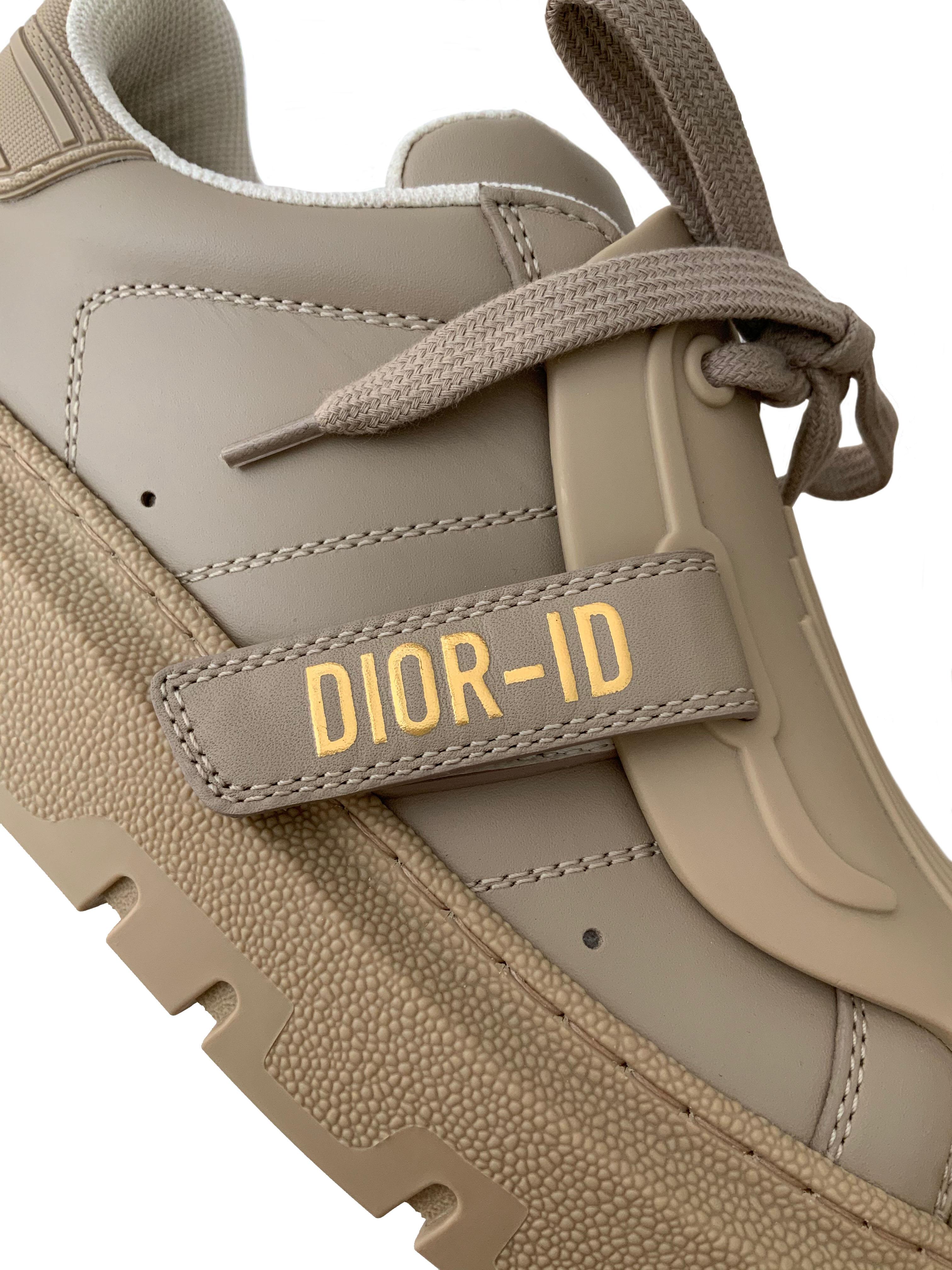 These pre-owned but NEW beige calfskin Dior-ID sneakers from the house of Christian Dior feature a textured and tonal rubber insert which conceals the laces.
The adhesive tongue shows a gold-tone Dior-ID signature.
The sole is made of notched rubber