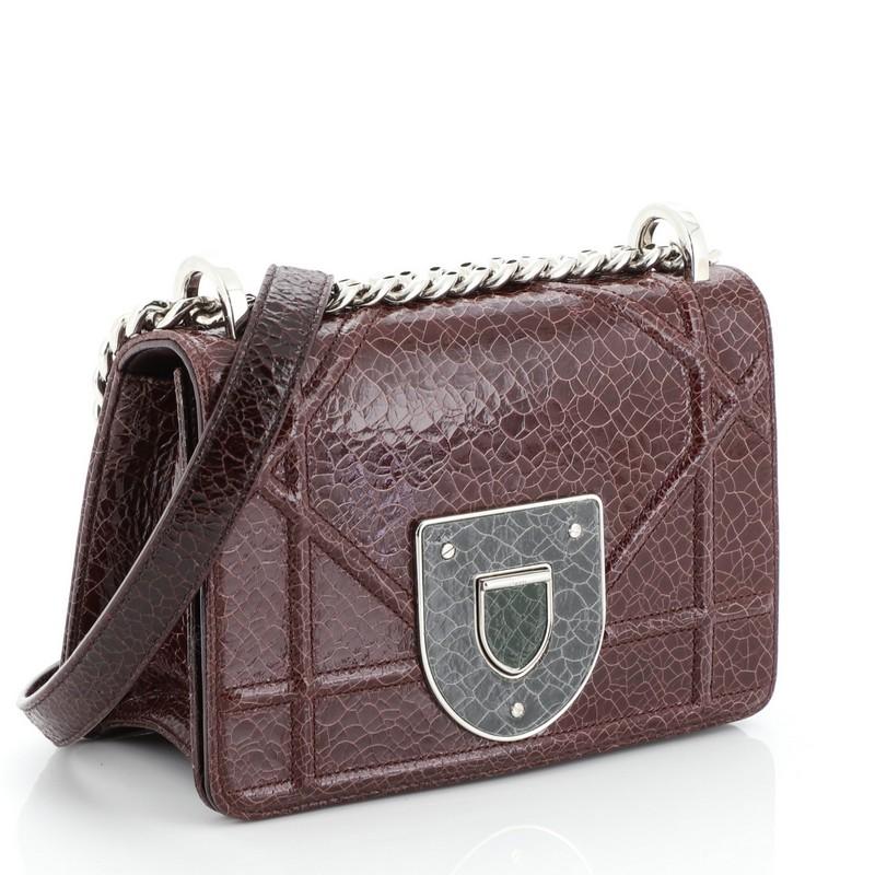 This Christian Dior Diorama Club Flap Bag Crackled Deerskin Small, crafted in red crackled deerskin, features an oversized graphic-style cannage quilting, chain link strap with leather pad, and silver-tone hardware. Its press-lock closure opens to a