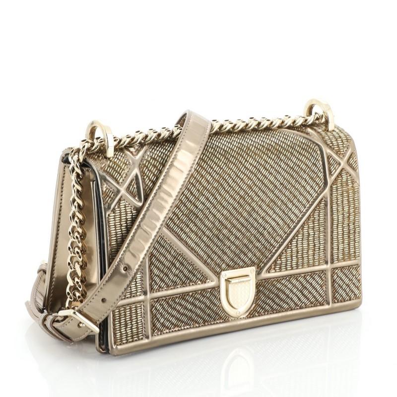 This Christian Dior Diorama Flap Bag Beaded Leather Small, crafted from metallic gold beads with gold leather, features embossed and stitched cannage lines, chain link strap with adjustable leather pad, and aged gold-tone hardware. Its crest-shaped