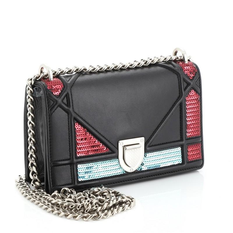 This Christian Dior Diorama Flap Bag Sequin Embellished Lambskin Mini, crafted from black leather, features embossed and stitched cannage lines, sequins embellishment, chain link strap, and silver-tone hardware. Its slide-press closure opens to