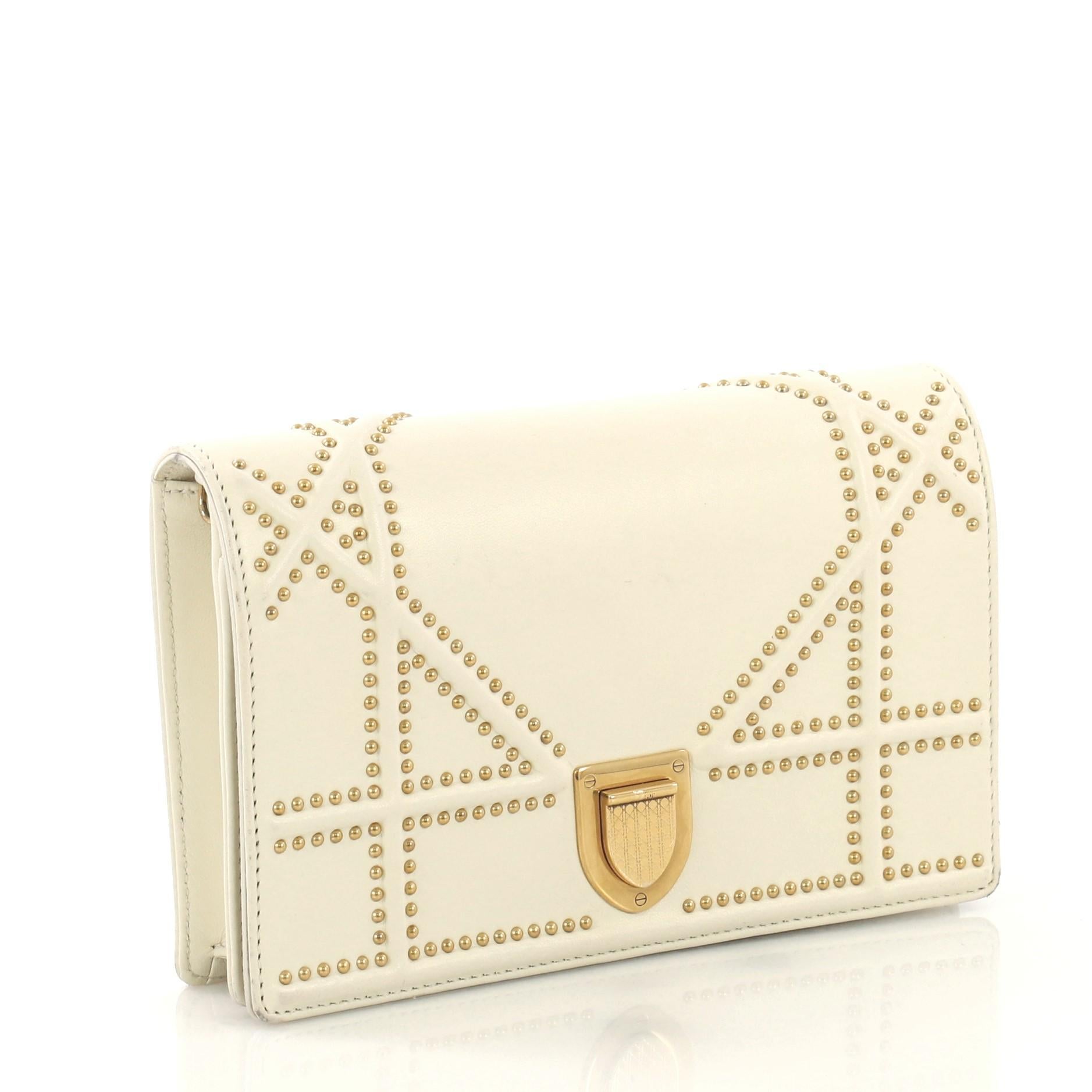 This Christian Dior Diorama Wallet on Chain Studded Leather, crafted from white cannage embossed leather with stud detailing, features chain link shoulder strap and gold-tone hardware. Its crest-shaped press closure opens to an off white suede and