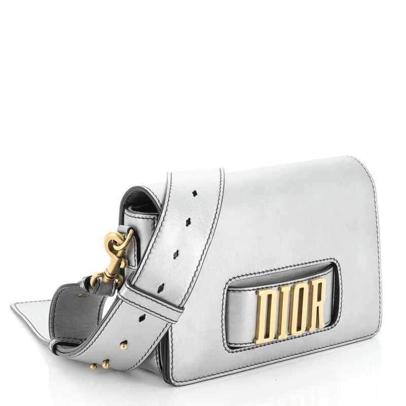 This Christian Dior Dio(r)evolution Flap Bag Leather Medium, crafted from silver leather, features a slot handclasp with DIOR emblem and matte gold-tone hardware. It opens to a gray suede interior with zip pocket. 

Estimated Retail Price: