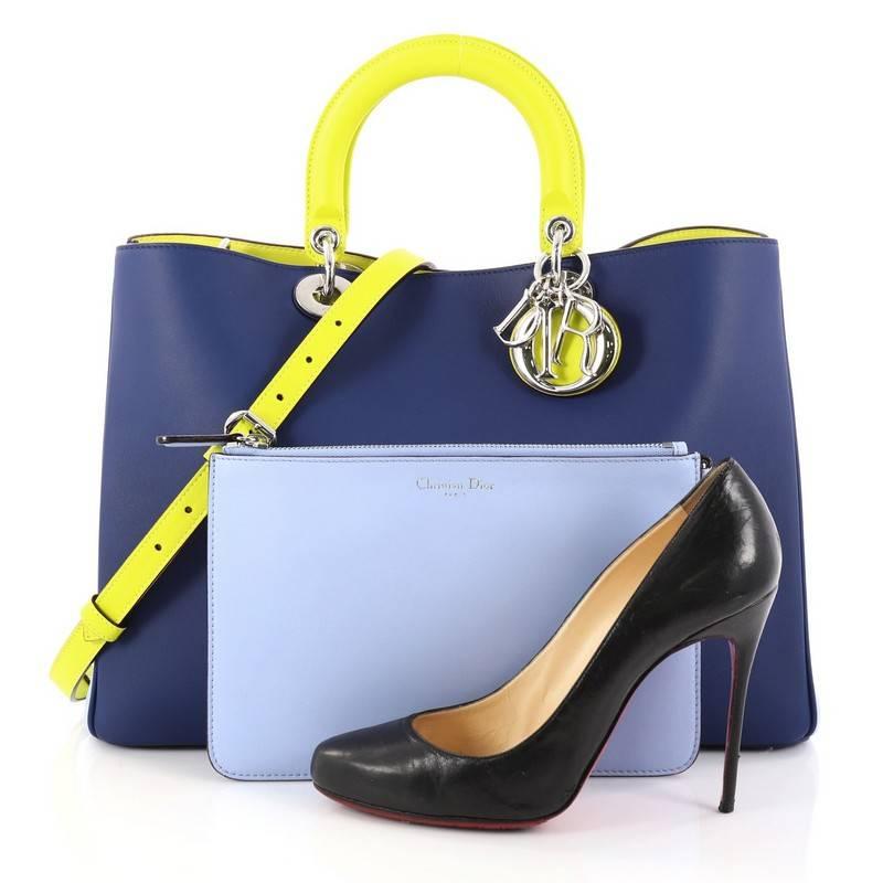 This authentic Christian Dior Diorissimo Tote Pebbled Leather Large is an elegant, classic statement piece that every fashionista needs in her wardrobe. Crafted from indigo and light blue pebbled leather, this chic tote features smooth neon citron