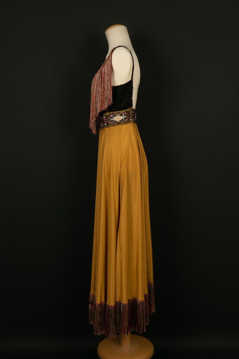 Dior - (Made in France) Dress in gold silk, collar and bottom of the dress edged with multicolored fringes and top of the dress embroidered. Size 38FR. To be noted, a few stains.

Additional information:
Dimensions: Chest: 43 cm, Waist: 32 cm,