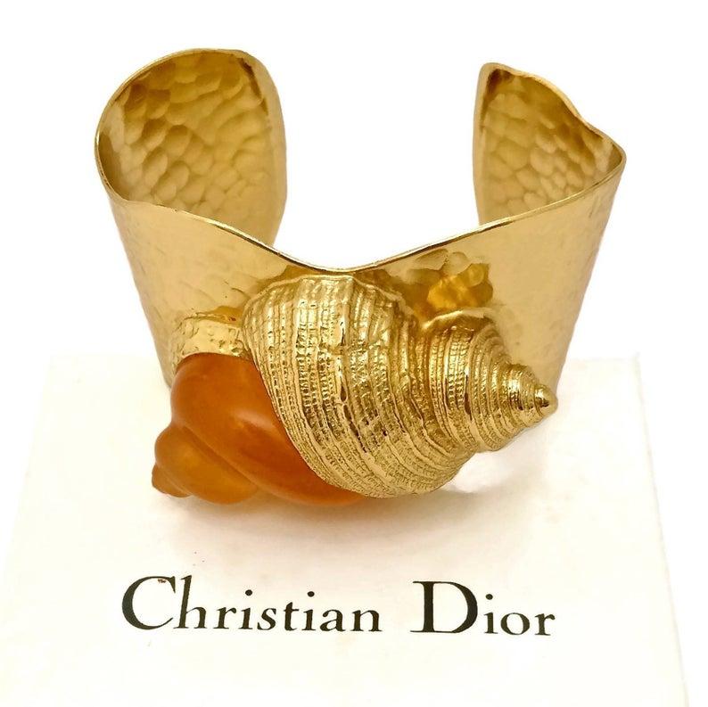Vintage CHRISTIAN DIOR DUNE by Robert Goossens Lucite Shell Hammered Cuff Bracelet

Measurements:
Height: 1 6/8 inches (4.45 cms)
Inside Circumference: 7 2/8 inches (18.41 cms)

Limited edition Christian Dior cuff designed by Robert Goossens for the