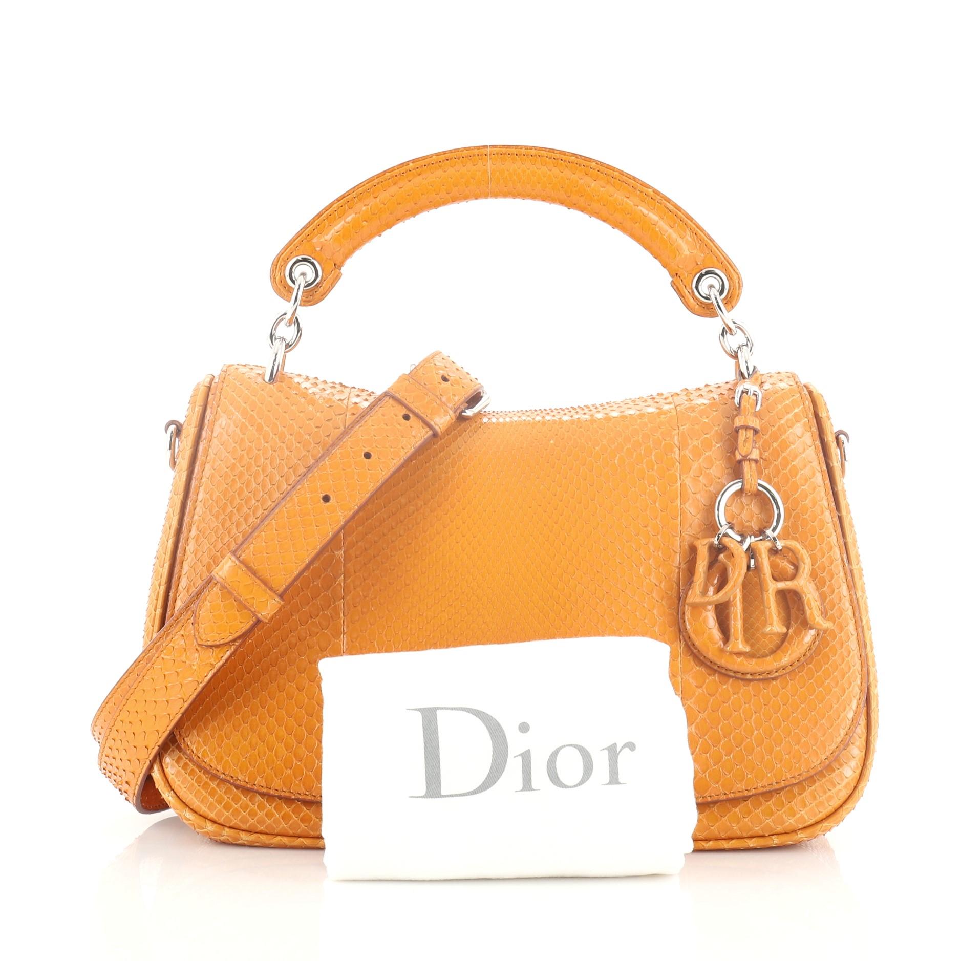 This Christian Dior Dune Top Handle Bag Python Medium, crafted in genuine yellow python, features a top handle and silver-tone hardware. Its zip closure opens to a yellow leather interior with slip pocket. This item can only be shipped within the