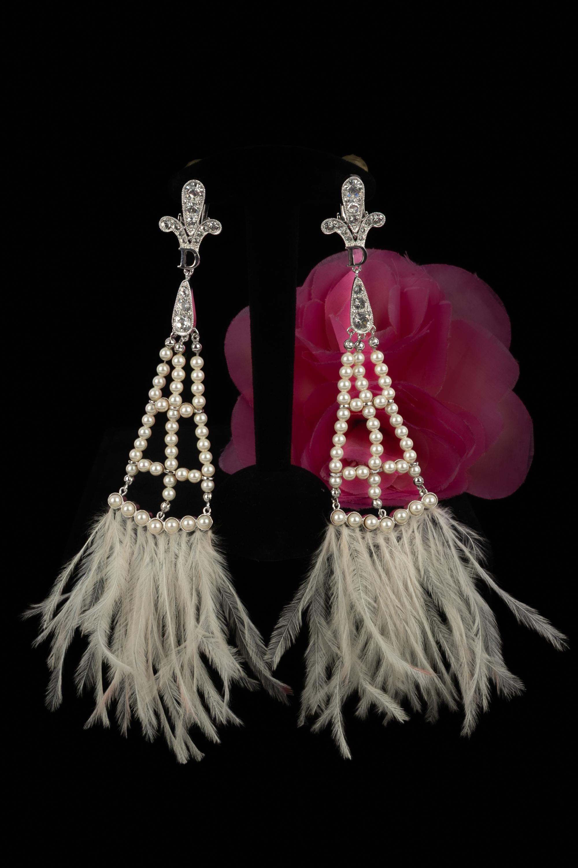 DIOR - Longues boucles d'oreilles en métal argenté ornées de strass, de perles fantaisie et de plumes blanches. Collectional printemps-été 2008 sous la direction artistique de John Galliano.

Condit :
Très bon état.

Dimensions :
Longueur totale :