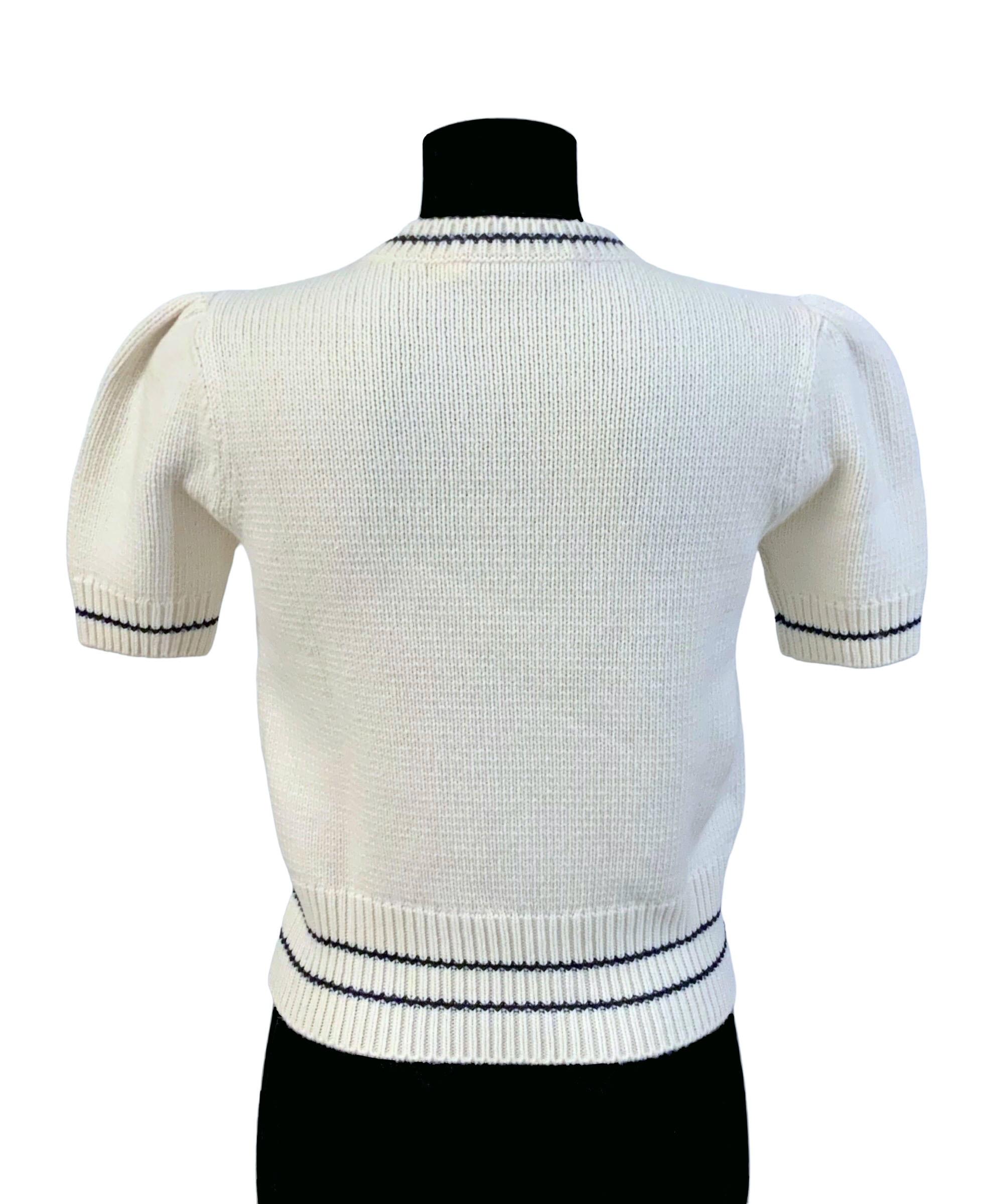 The sweater is elegant yet modern !
Delicately crafted in an ecru cashmere and wool knit, it highlights the House's lucky star as well as the 'CHRISTIAN DIOR' signature both hand - embroidered. 
It features slightly puffed short sleeves and a ribbed