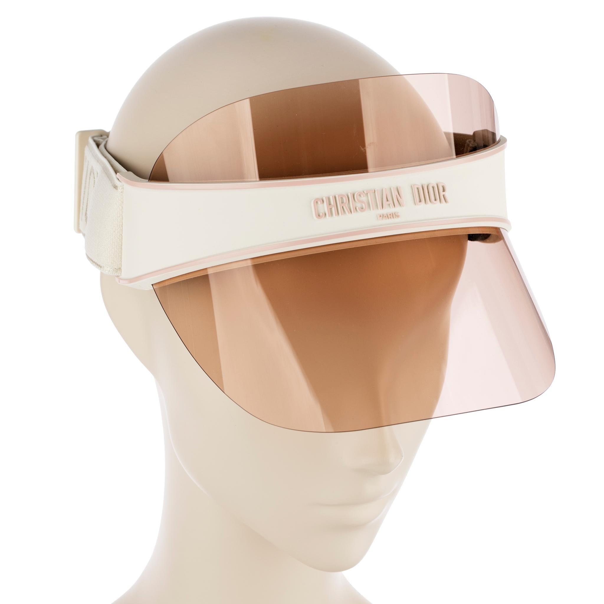 Brand: Christian Dior
Product: Dior Club V1U Tinted Sun Visor
Size: Adjustable
Colour: Nude, Cream & Pink

Details:
- Nude tone mirrored sun visor with Christian Dior logo
- Adjustable cream jacquard stretch head band
- Made in