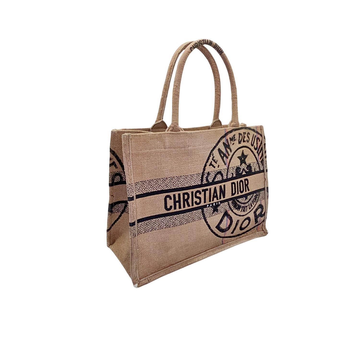 Indulge in luxury with the Christian Dior Embroidered Canvas Jute Medium Book Tote. Crafted in Italy, this tote boasts a unique blend of beige jute canvas and black, red, and blue printed accents. The spacious interior and rolled canvas handles make