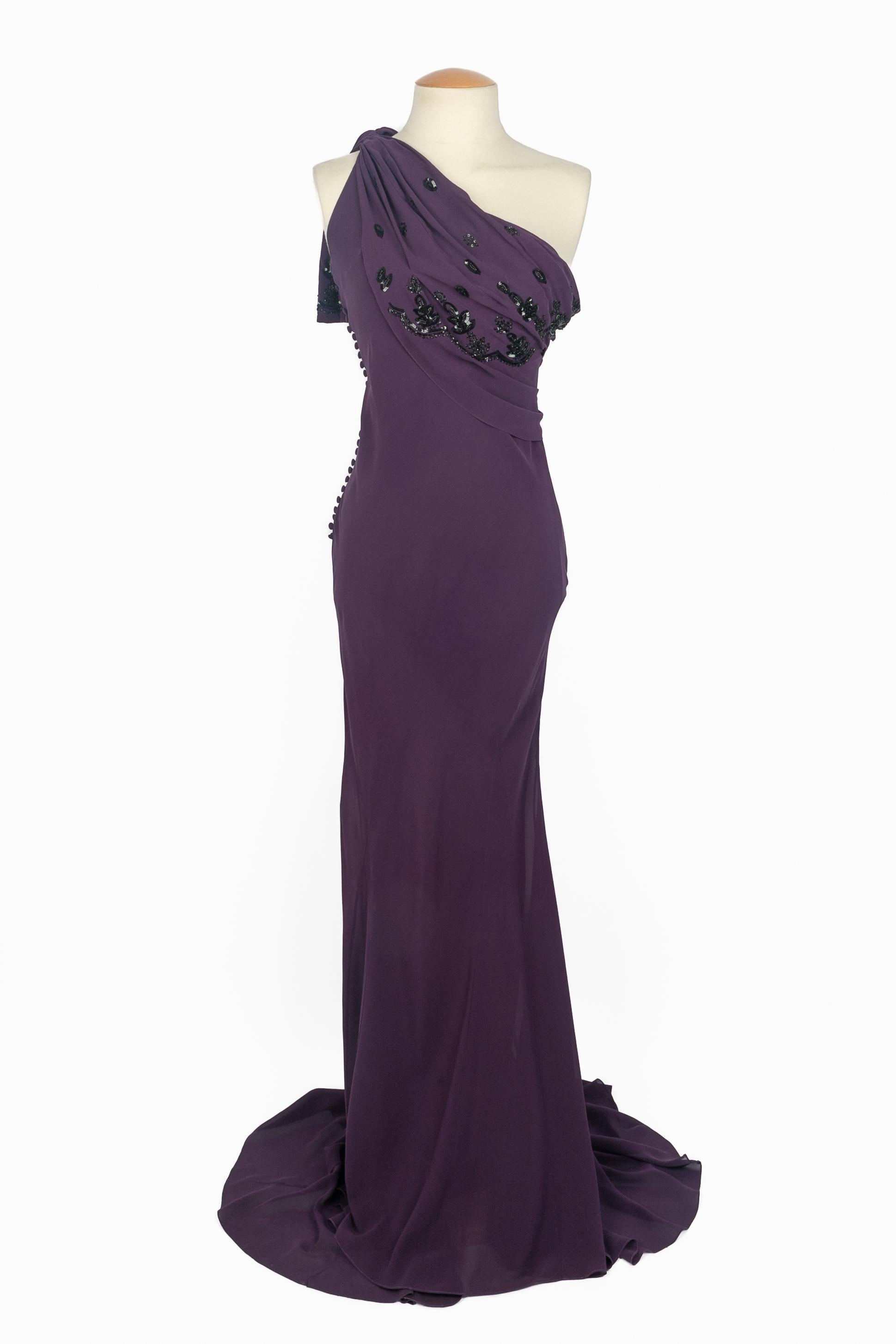 DIOR - (Made in France) Pflaumenfarbenes Abendkleid aus Seidenmusselin mit Schr�ägschnitt. Eine Schulter mit Drapierung ist mit perlenbesetzten Blättern und schwarzen Pailletten verziert. Größe 36FR angegeben. Eine Collection'S 2008 unter der