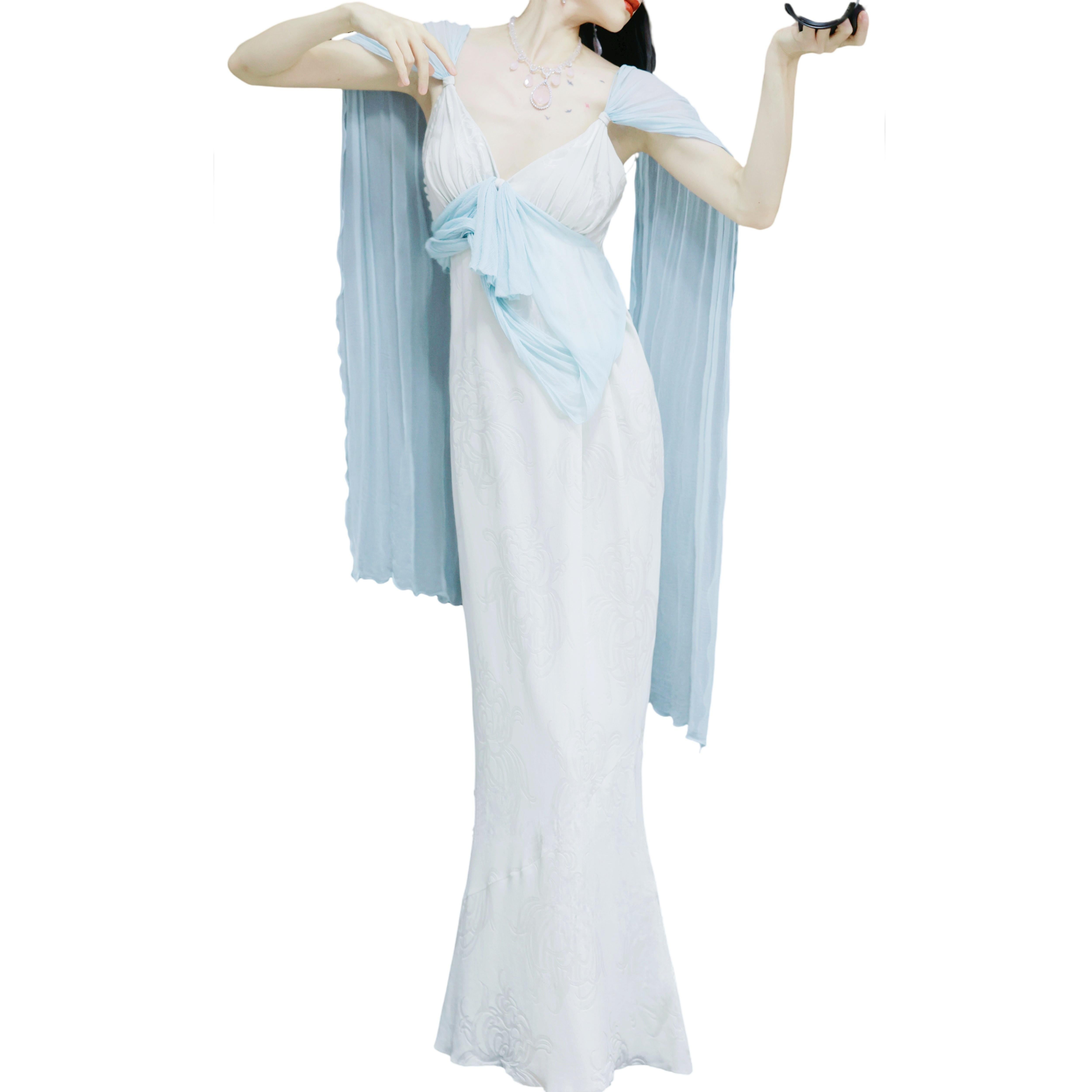 Este vestido de la primavera-verano de 2005, diseñado por John Galliano, es un precioso y elegante vestido largo hasta el suelo que desprende un encanto suave y romántico. El cuerpo principal está confeccionado con un tejido ligero y cremoso