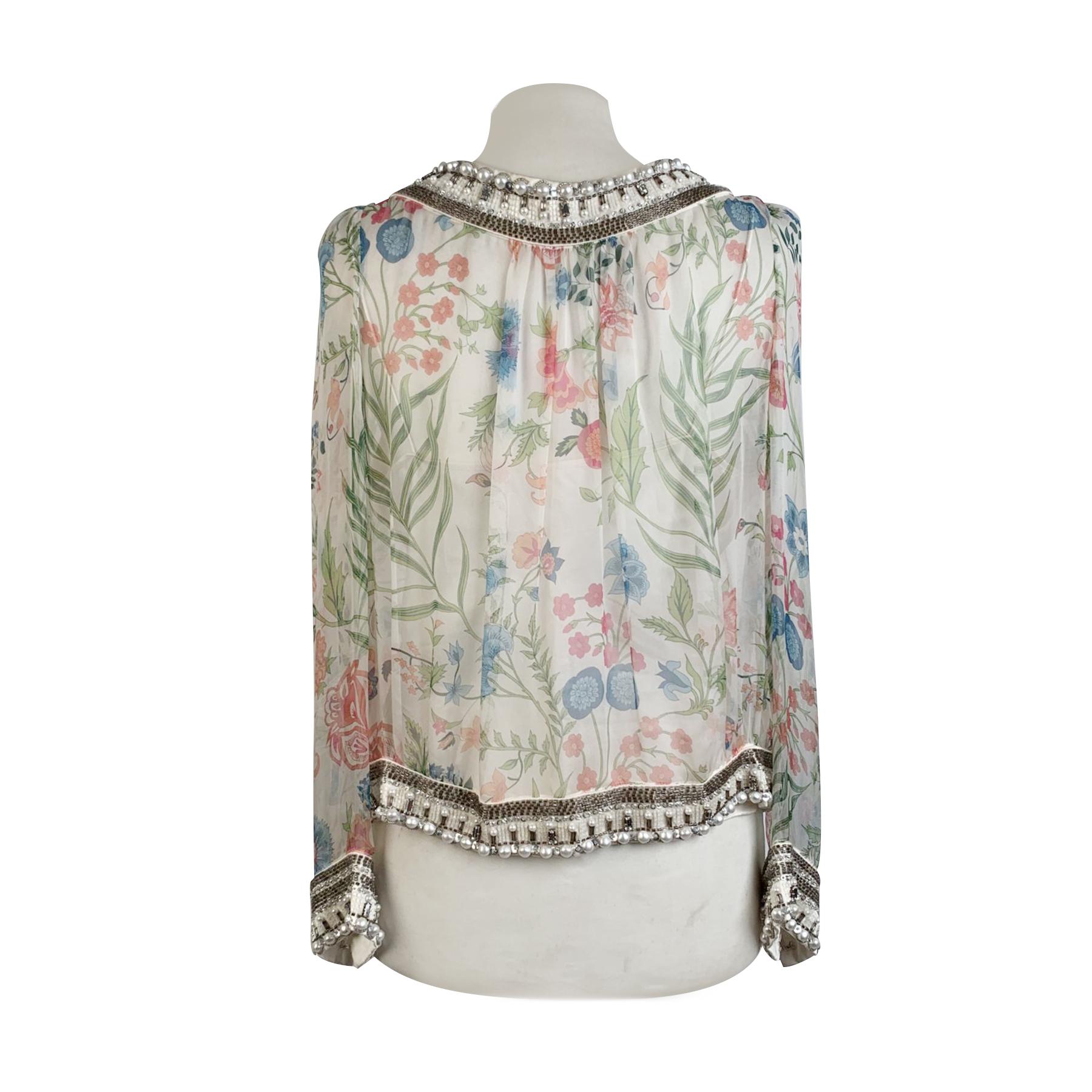 Christian Dior embellished layered top in silk chiffon. Sheer fabric. It features beads and crystale embellishemrnt along the satin trim, bow detailing, long sleeve styling with hook and eye closure, and a silk satin cami top underlay, Composition