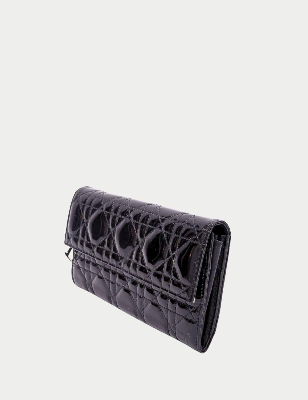 Entra nel lusso con questo portafoglio Christian Dior Lady Dior, un accessorio iconico della leggendaria casa di moda francese.

Realizzato in vernice nera lucida, il portafoglio presenta le cuciture trapuntate Cannage, segno distintivo della linea