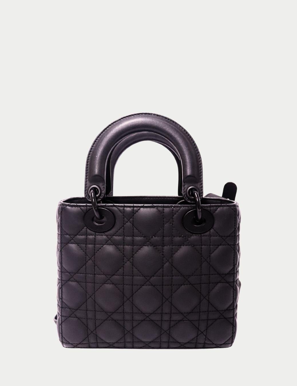 Icône et intemporel, ce sac Lady Dior de Christian Dior en cuir d'agneau noir est un véritable symbole d'élégance et de savoir-faire. Conçu avec les coutures matelassées Cannage, signature de Dior, ce sac à main structuré est immédiatement