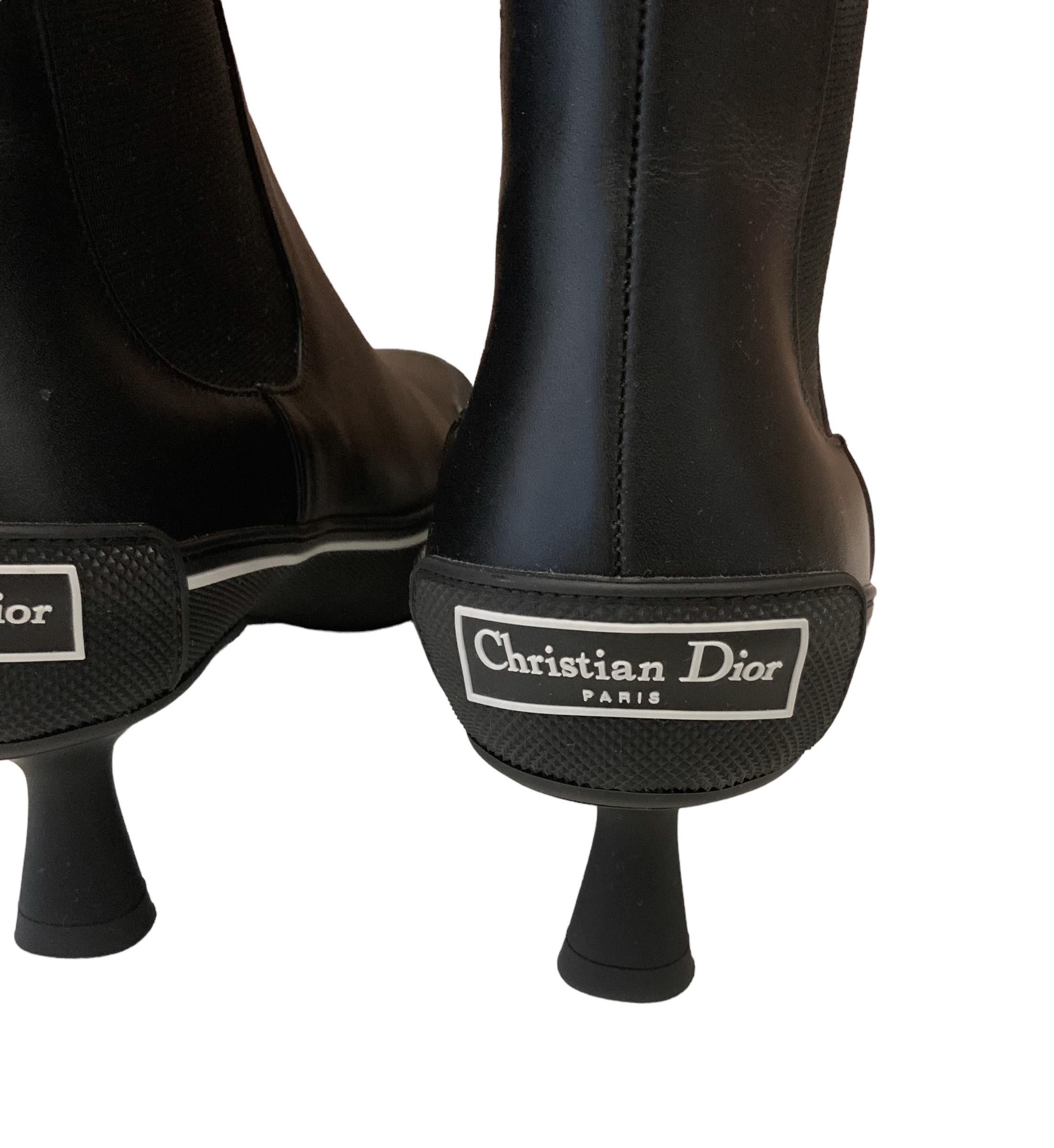 These pre-owned but new D-Motion heeled ankle boot features a hybrid design, mixing a Chelsea boot with elements borrowed from sportswear. 
Crafted in black supple calfskin with stretch bands on the sides.
The sole and heel are made of black rubber.