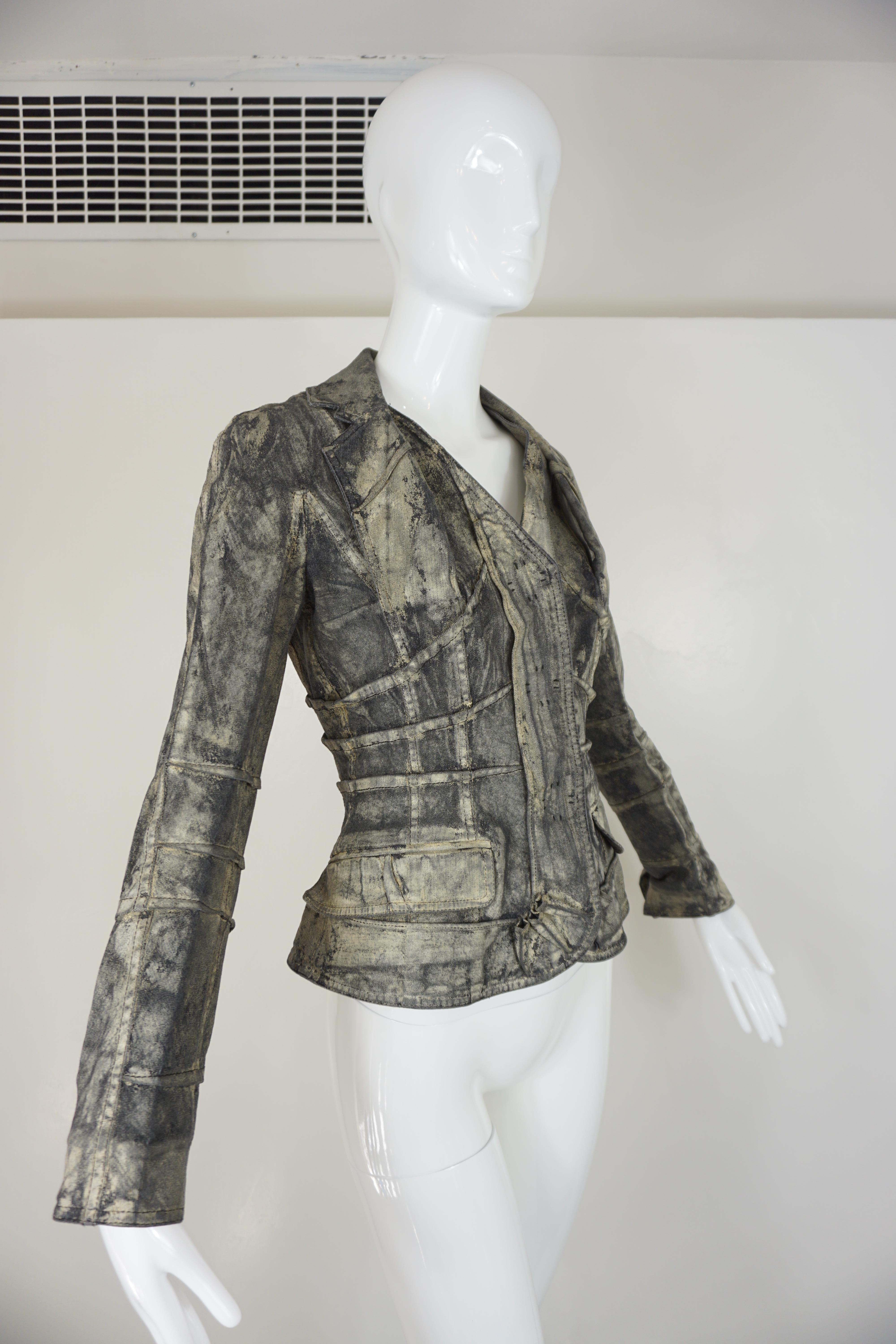 Christian Dior Boutique jacket, from the Fall 2006 Ready-to-Wear, is featured in distressed blackened cream overlay washed denim with welted corset tailoring throughout, creating a peplum design. The jacket features large Christian Dior labeled snap