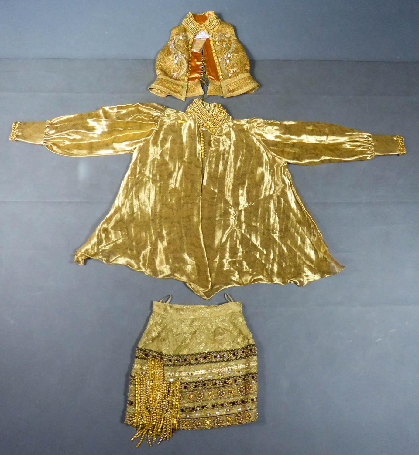 Circa 1990
France

Rich and extravagant Christian Dior set with bolero, shirt and skirt in lamé and gold brocade of Asian and Thai inspiration by Mister Gianfranco Ferré and dating from the beginning of the 1990s. Embroidery in abundance of golden