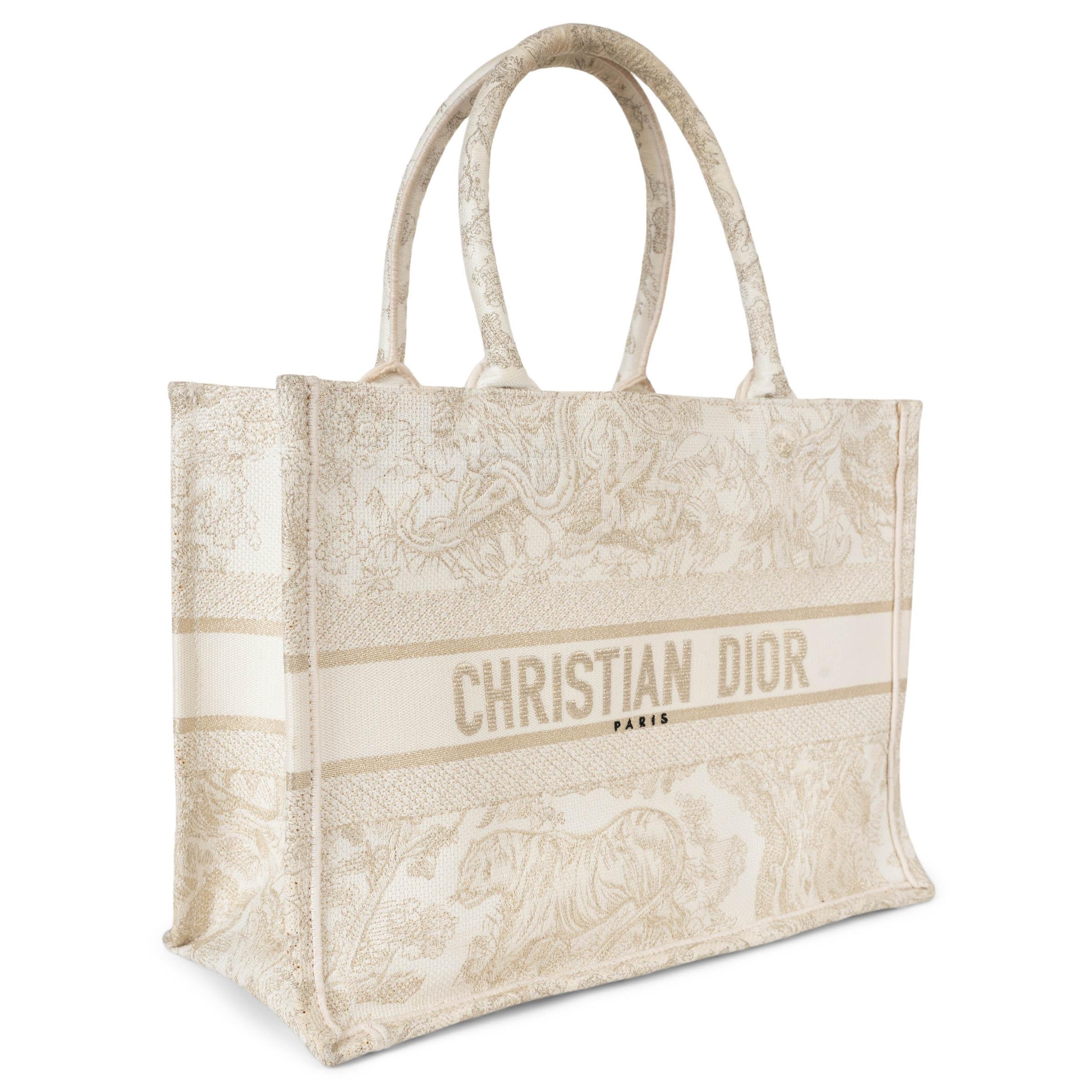 Ce fourre-tout moyen Christian Dior, 100% authentique, est réalisé en toile de Jouy brodée or et blanc, délicatement tissée de fils de lurex dorés scintillants pour une finition luxueuse. Arborant la signature emblématique de Christian Dior sur le