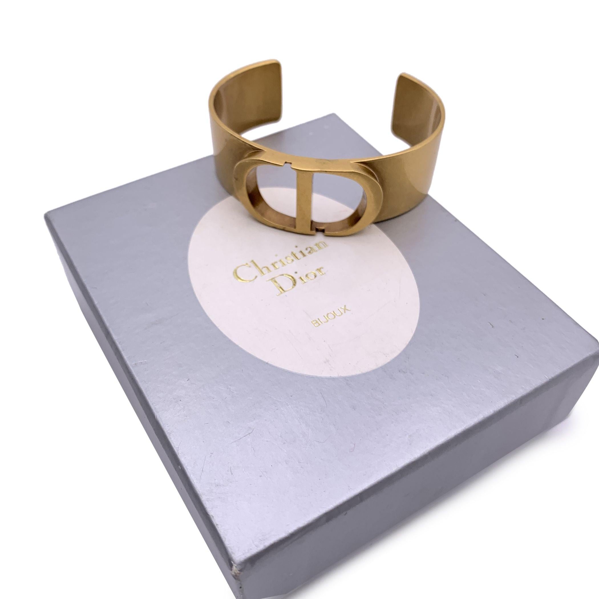 CHRISTIAN DIOR Metall 30 Montaigne Manschettenarmband. Das Armband ist aus goldenem Metall gefertigt und zeigt eine CD auf der Vorderseite. DIOR-Signatur am Ende des Armbands eingraviert. Innerer Umfang: 6,25 Zoll - 15,8 cm Zustand A - AUSGEZEICHNET