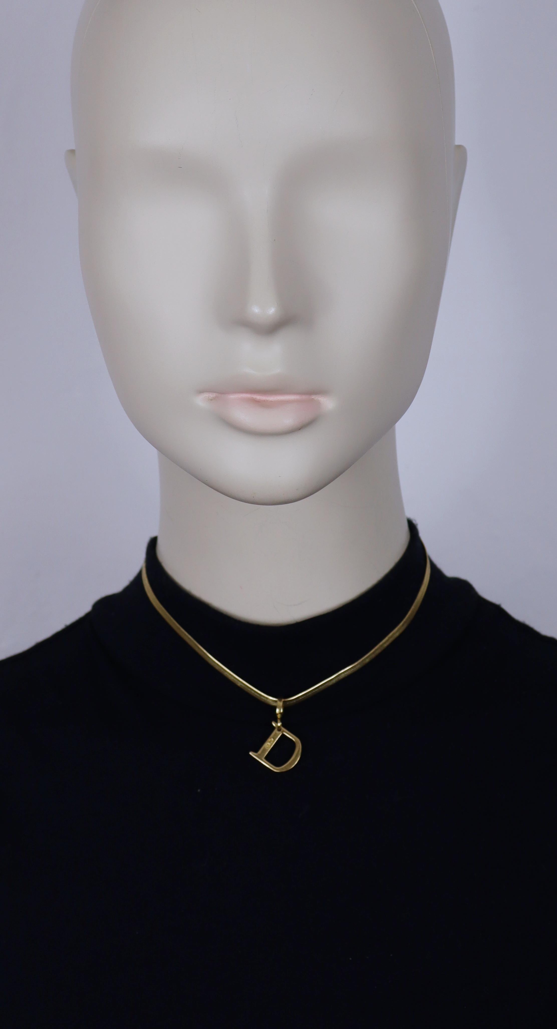 CHRISTIAN DIOR goldfarbenes, flaches Fischgrätencollier mit einem Anhänger mit der Initiale D.

Verstellbarer Karabiner-Verschluss.

Geprägte DIOR.

Ungefähre Maße: verstellbare Länge von ca. 32 cm (12,60 Zoll) bis ca. 36 cm (14,17 Zoll) / D