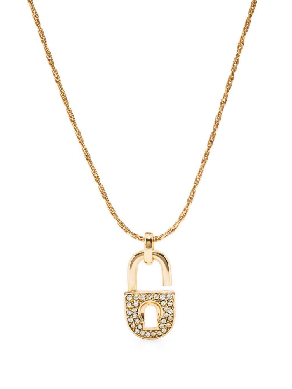 Christian Dior Gold-tone padlock pendant necklace featuring a front gold-tone and strass padlock medal, a logo fastening, an adjustable fit, spring-ring fastening.
Length: 16.9in (43cm)
Circa: 1990s
In good vintage condition. Made in France.
We