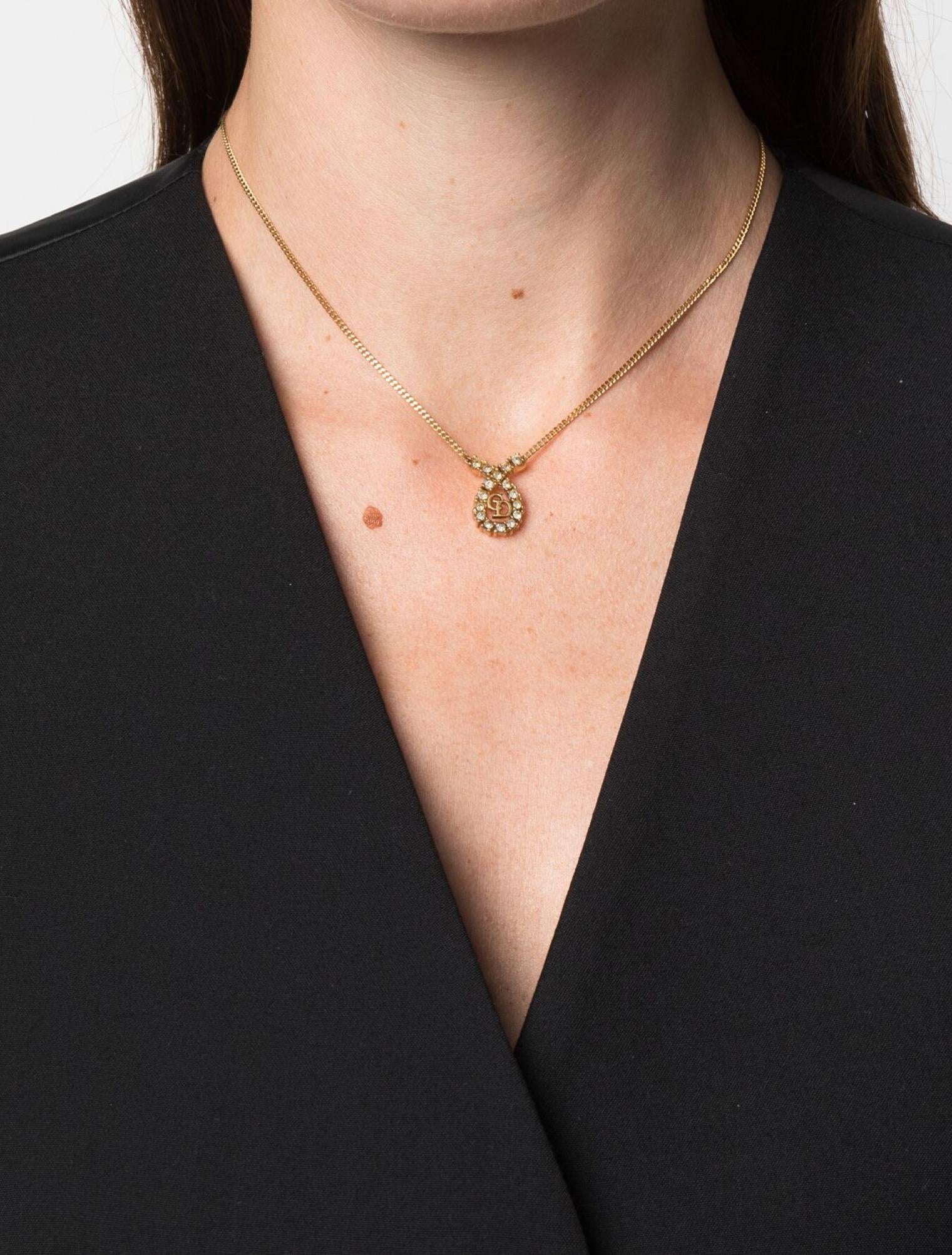 Christian Dior Gold-tone necklace featuring a thin chain, a logo pendant with a center medal with crystal and 