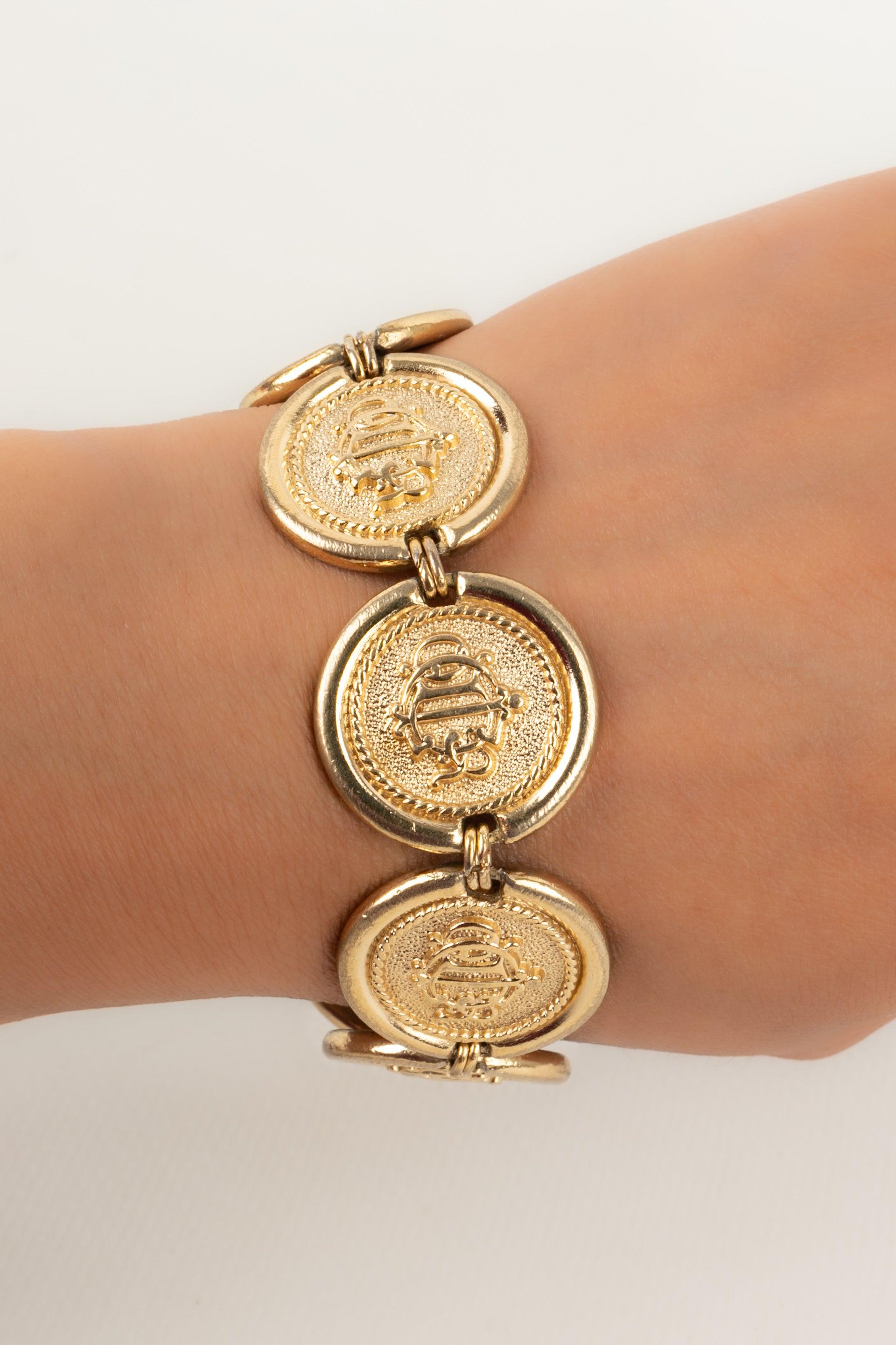 Dior - Golden metal bracelet representing coins.

Additional information:
Condition: Good condition
Dimensions: Length: 19 cm

Seller Reference: BRA60