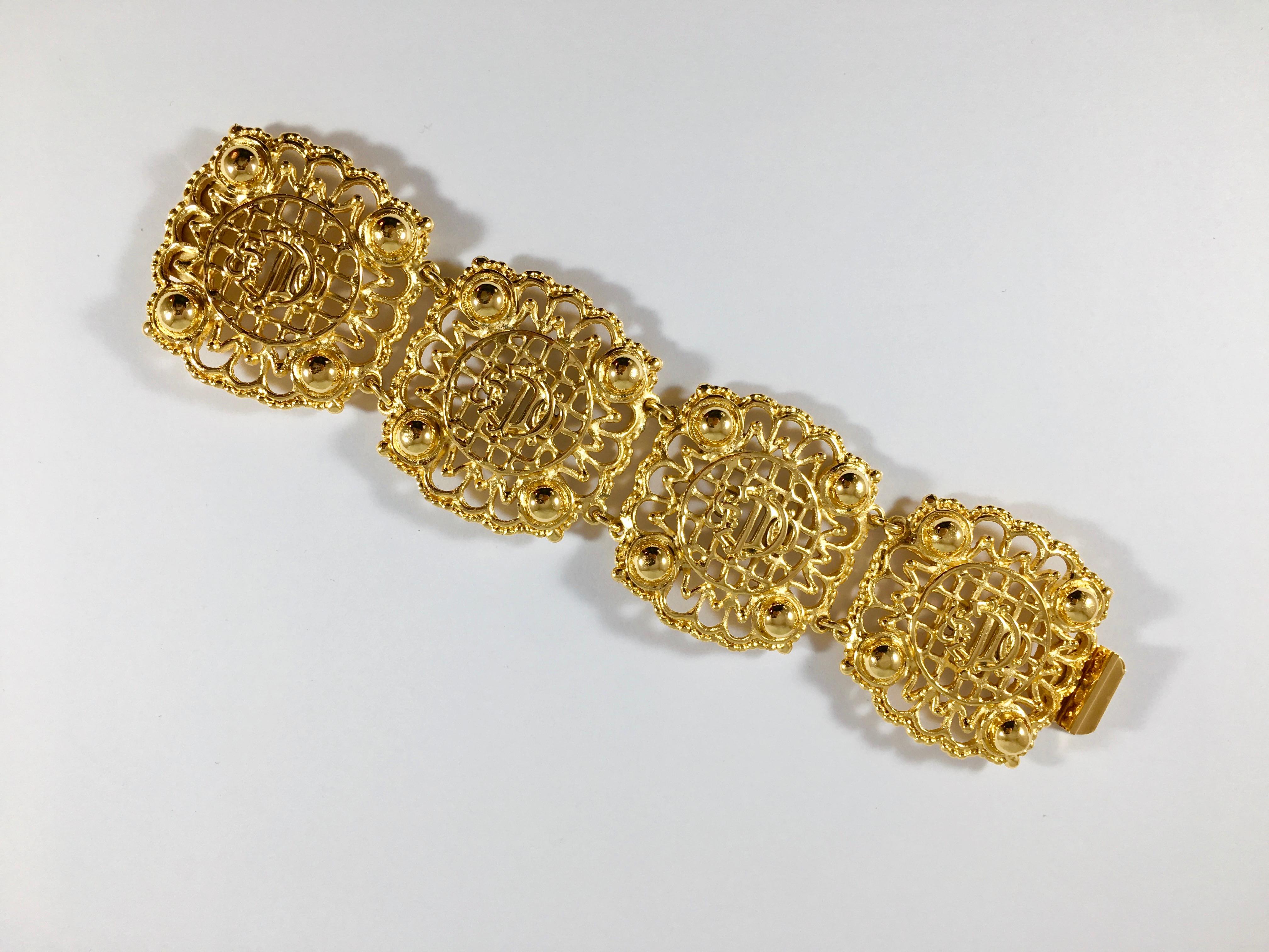 This is a beautiful 1980s Christian Dior gold-tone logo bracelet. It features the interlocking Christian Dior monogram used by Dior since the 1950s. the monogram is placed in the center of four open-work pieces that make up the bracelet. It features