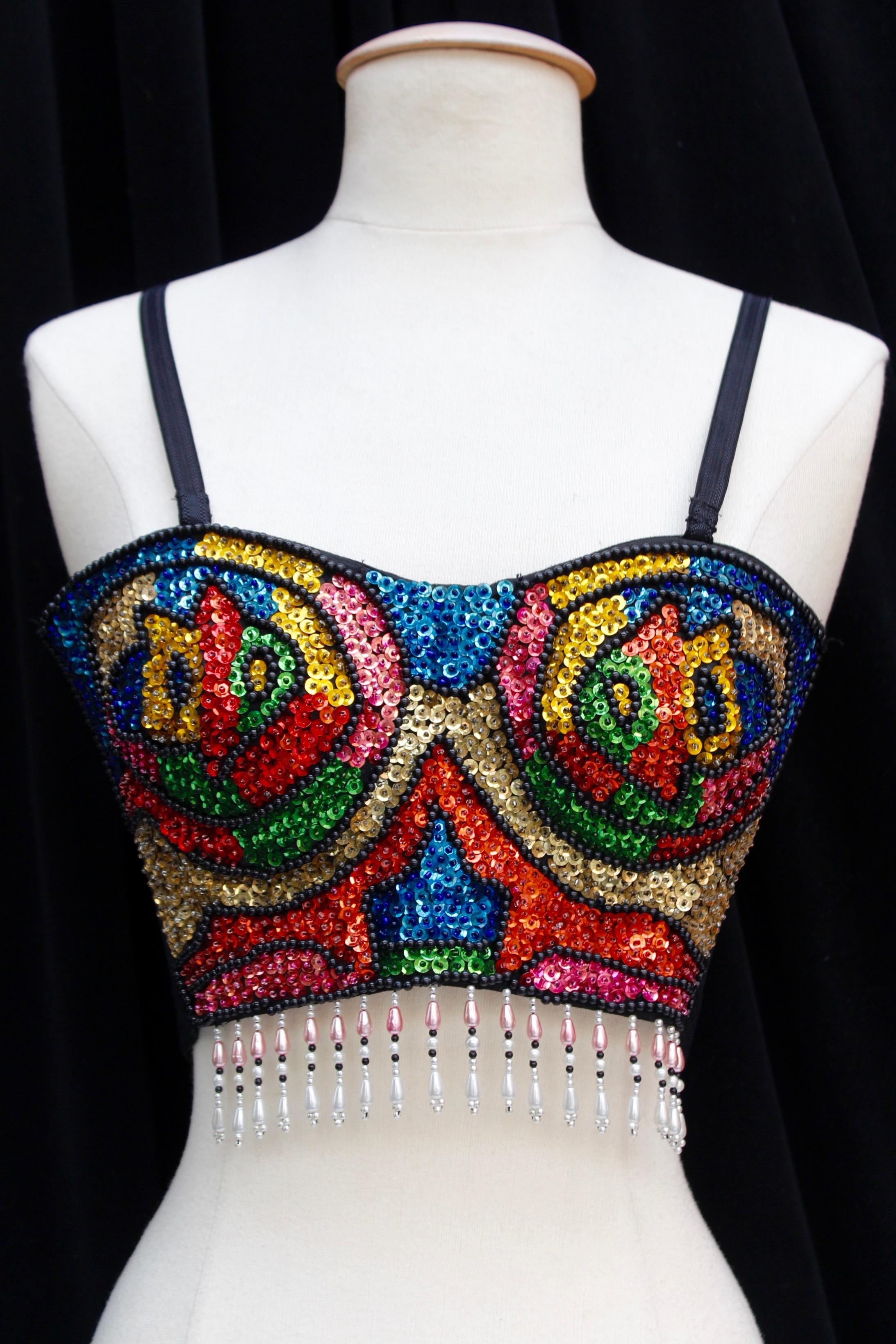 CHRISTIAN DIOR (Made in France) Gorgeous bustier with thin shoulder straps, composed of elastic nylon embroidered with multi color beads and sequins representing an abstract pattern. The bottom of the piece is further decorated with fringes composed